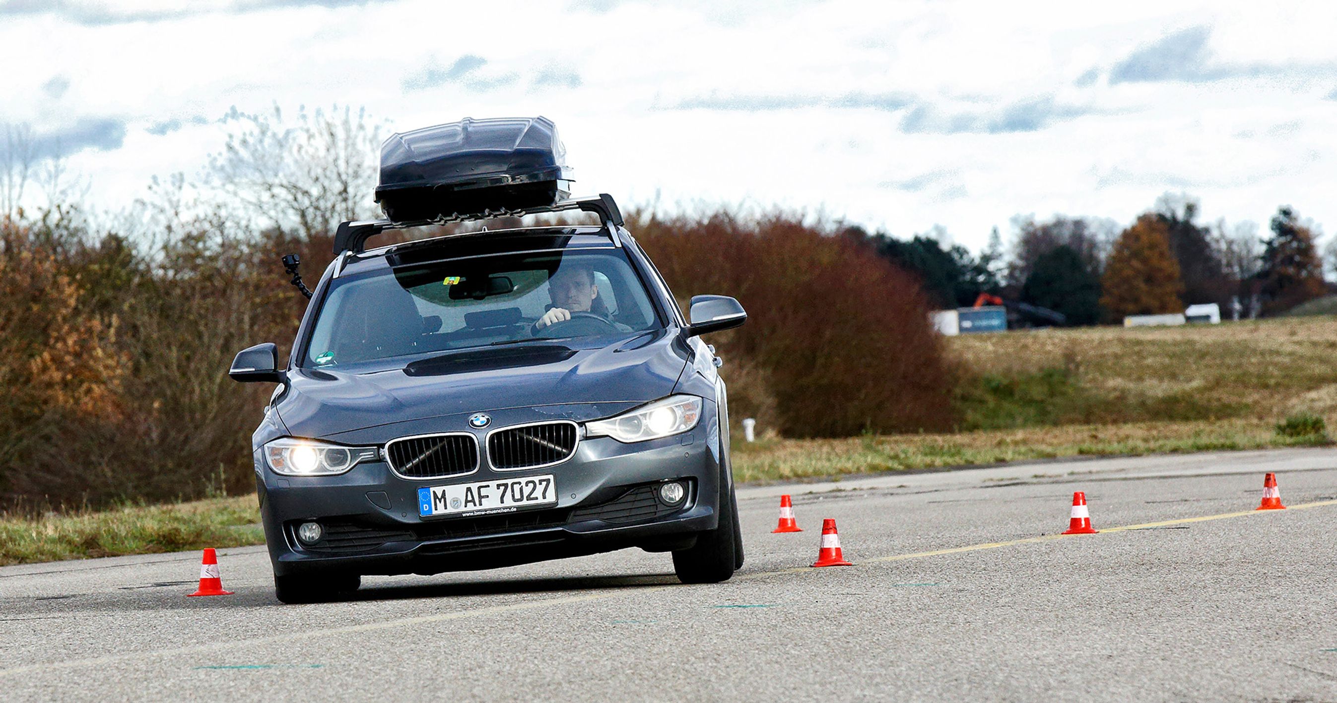 Bil kører på testbane med tagboks på taget.