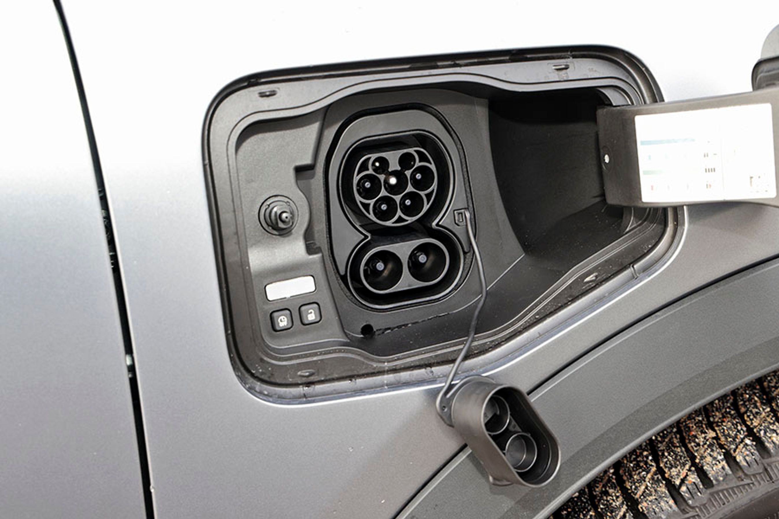 Ladestikket er placeret ved højre forhjul. Hjemme kan bilen oplades med enten 11 eller 22 kW, og på farten kan bilen oplades med op til 130 kW. Bemærk udløserknappen, der gør det muligt let at frigøre ladekablet.