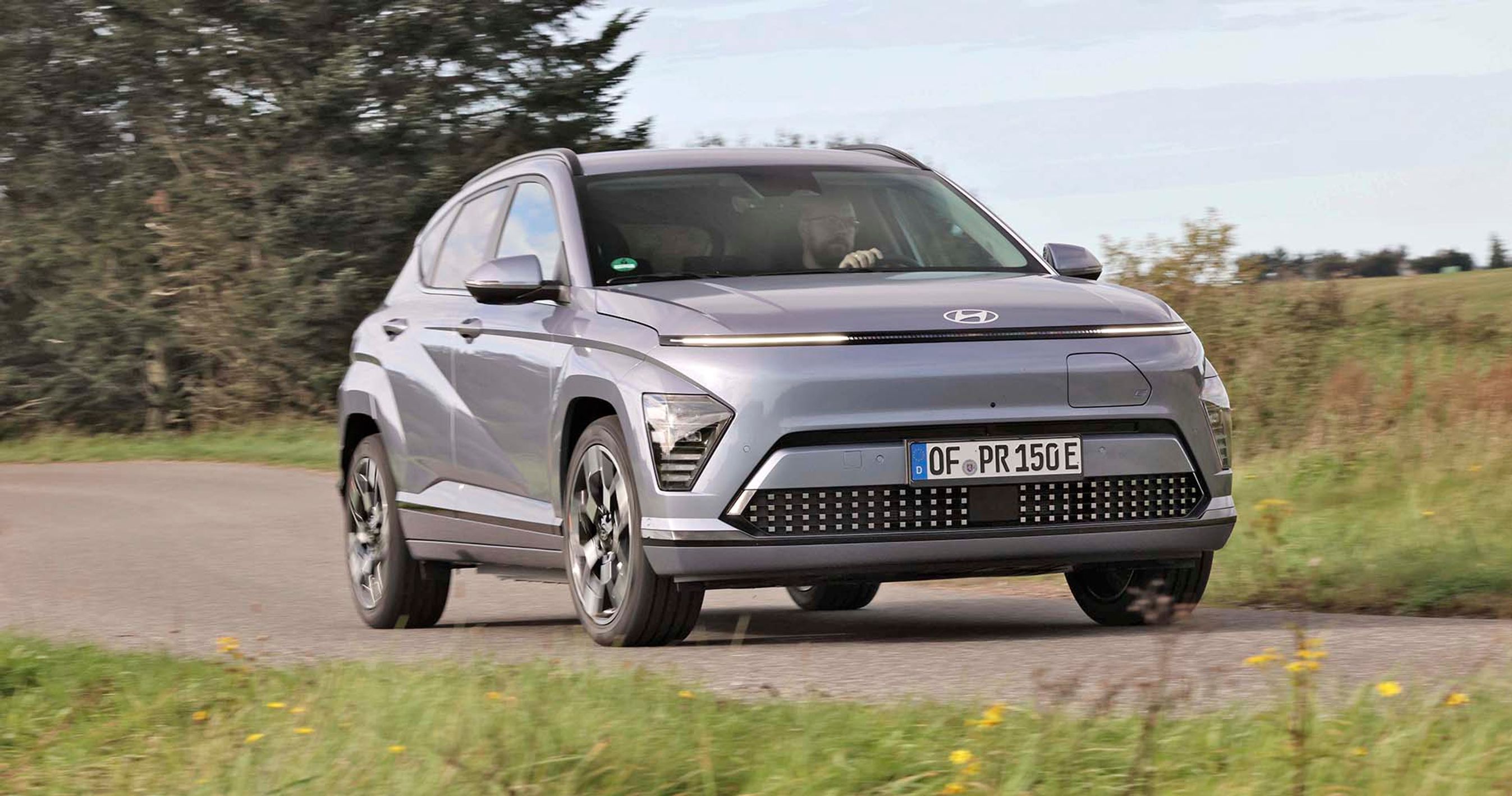 Elbilen Hyndai Kona set forfra, mens den kører gennem et sving på en landevej