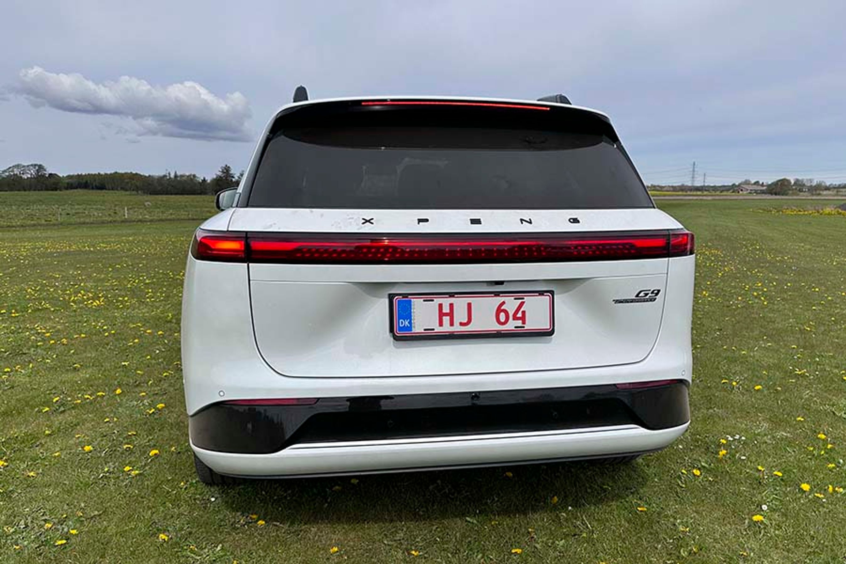 Baglygterne løber i hele bilens bredde, og oven over dem står XPENG med sorte bogstaver. En bagrudevisker er skjult under spoileren.