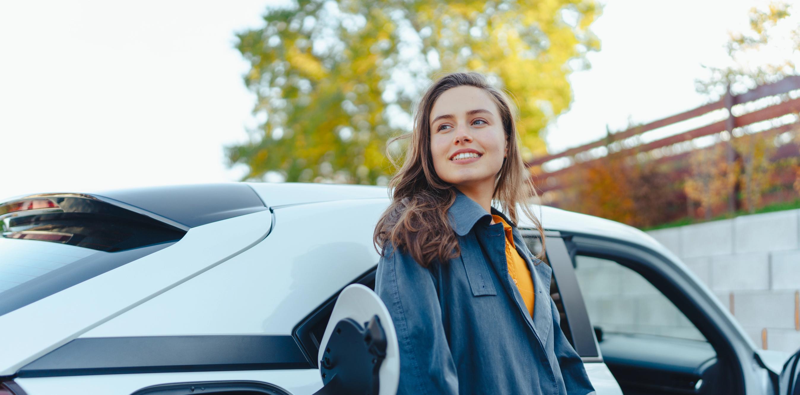 kvinde står op af en elbil mens den lader