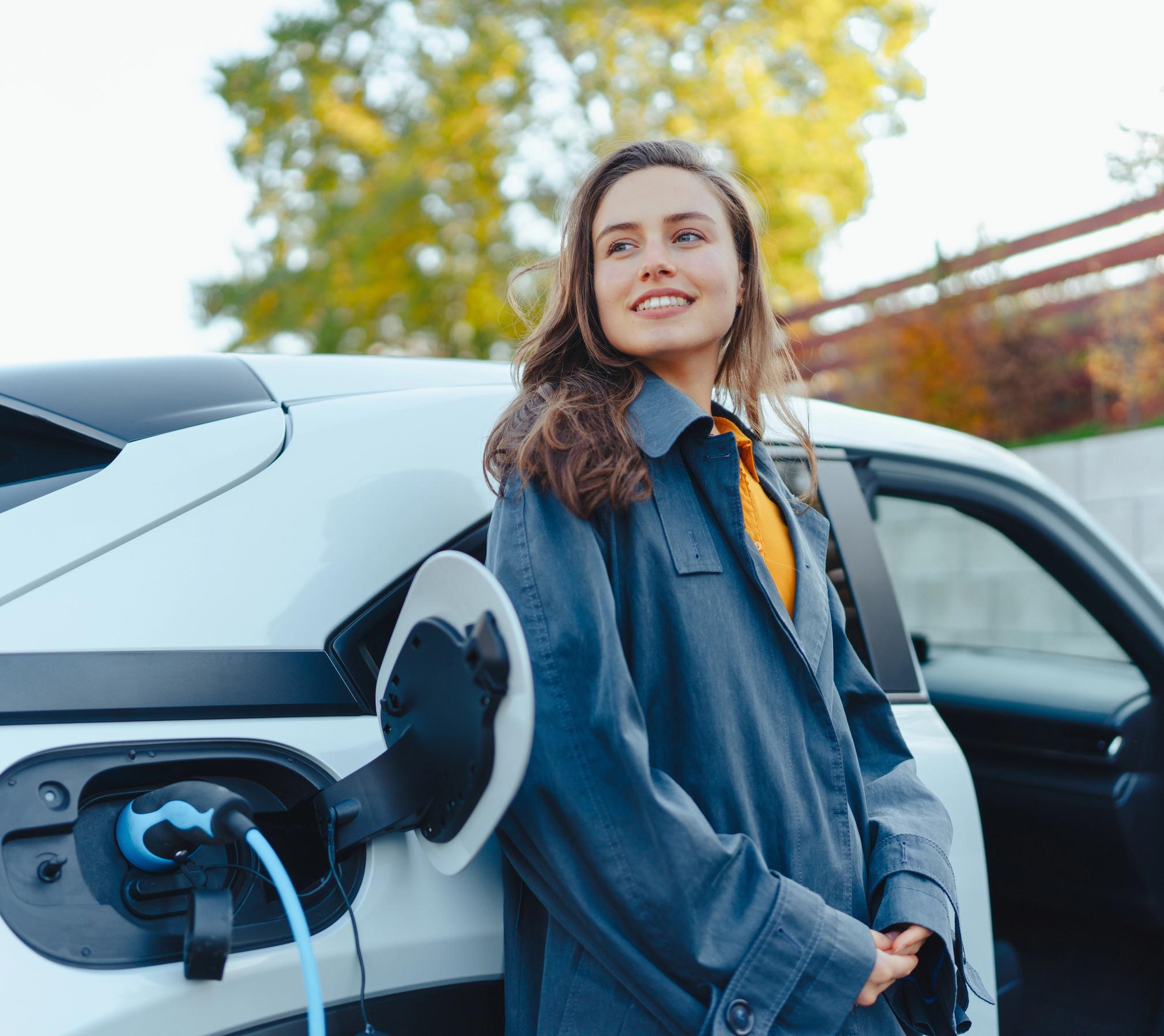 kvinde står op af en elbil mens den lader - FDM ladeløsning