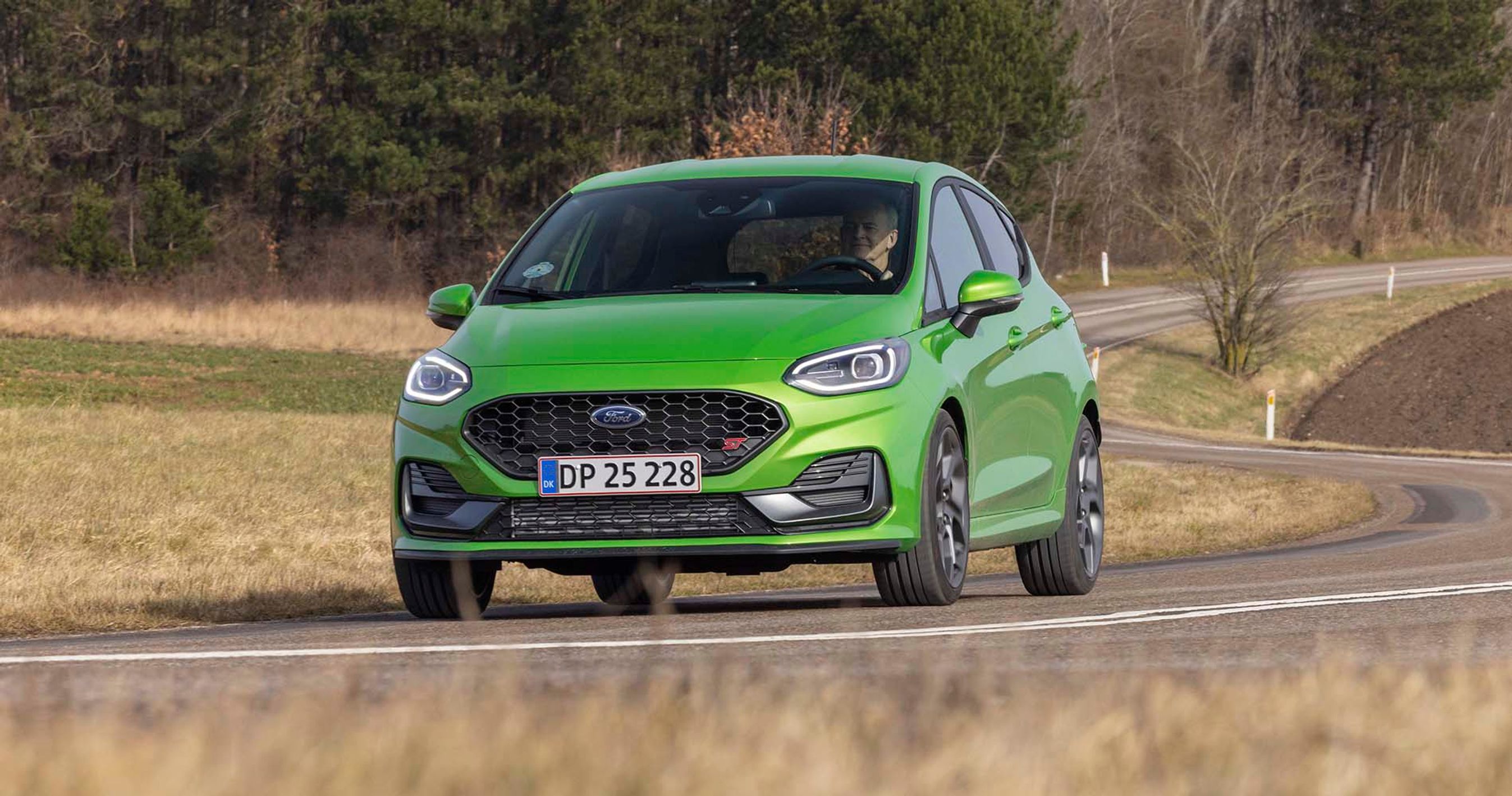 En grøn Ford Fiesta kører på en snoet landevej