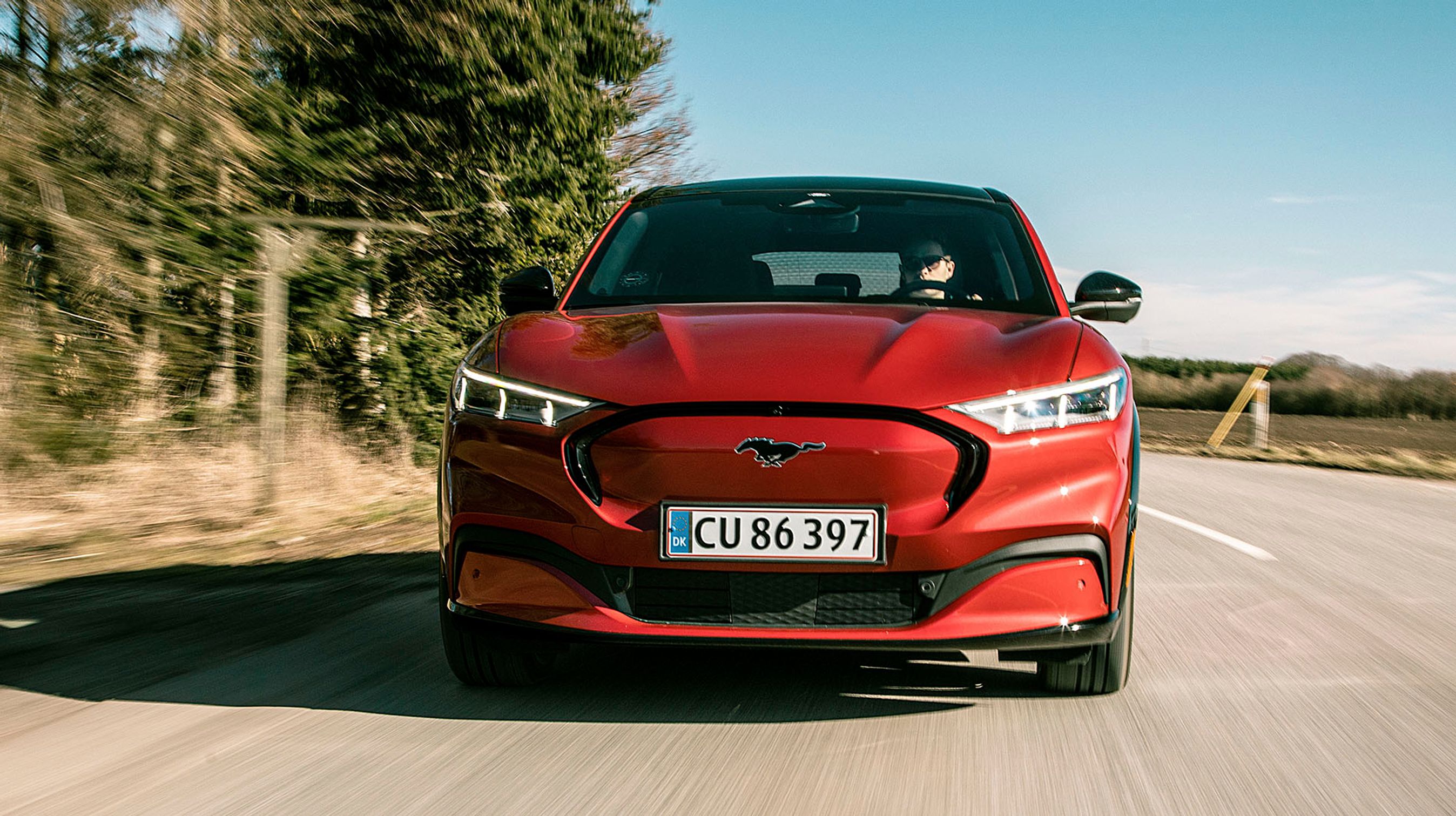 Ford Mustang Mach-E er en ny elbil, der er udformet som en blanding mellem en SUV og en sportsvogn. Det sorte tag skjuler det høje tag, så man mest ser coupé-linjerne.