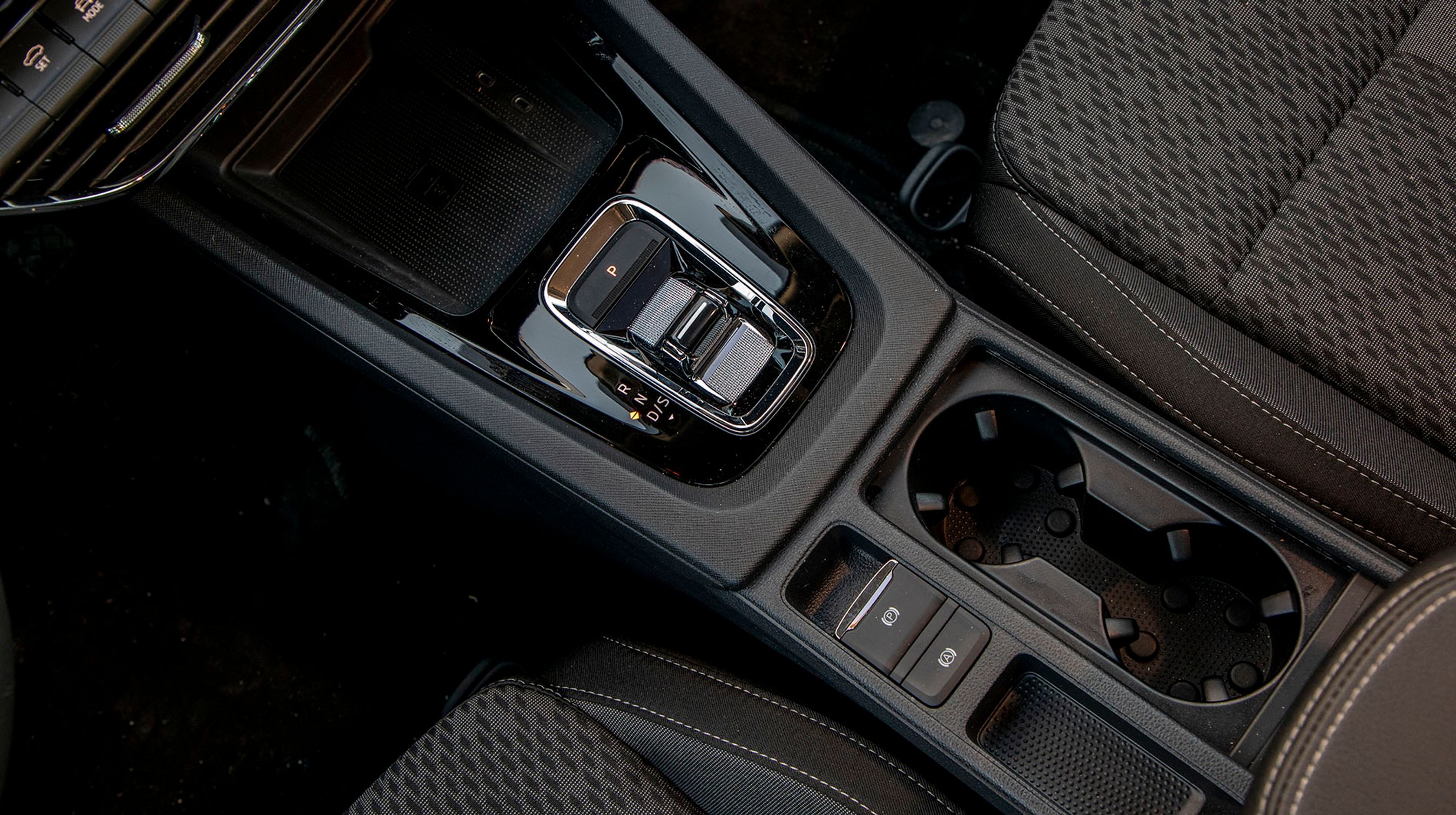 Den lille gearvælger mellem forsæderne er let at betjene, og er af den elektroniske type, der selv springer i P, når motoren slukkes. Der er fin fralægningsplads til en mobiltelefon forrest og to rimelige kopholdere bagtil.