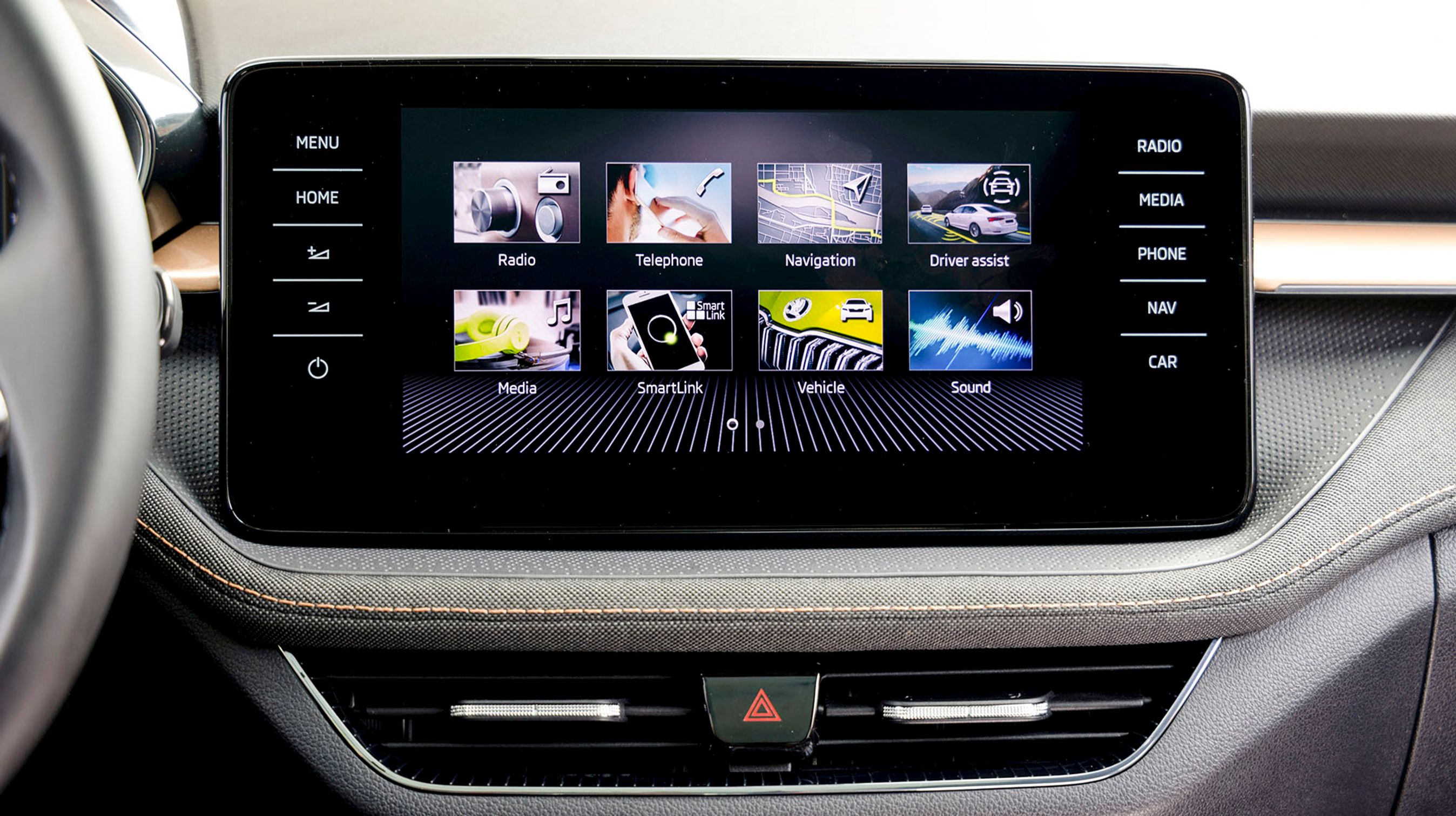 Skærmen i midten er her på 9,2 tommer og har indbygget trådløs Apple CarPlay og Android Auto. Bemærk stofbeklædningen på panelerne under skærmen.