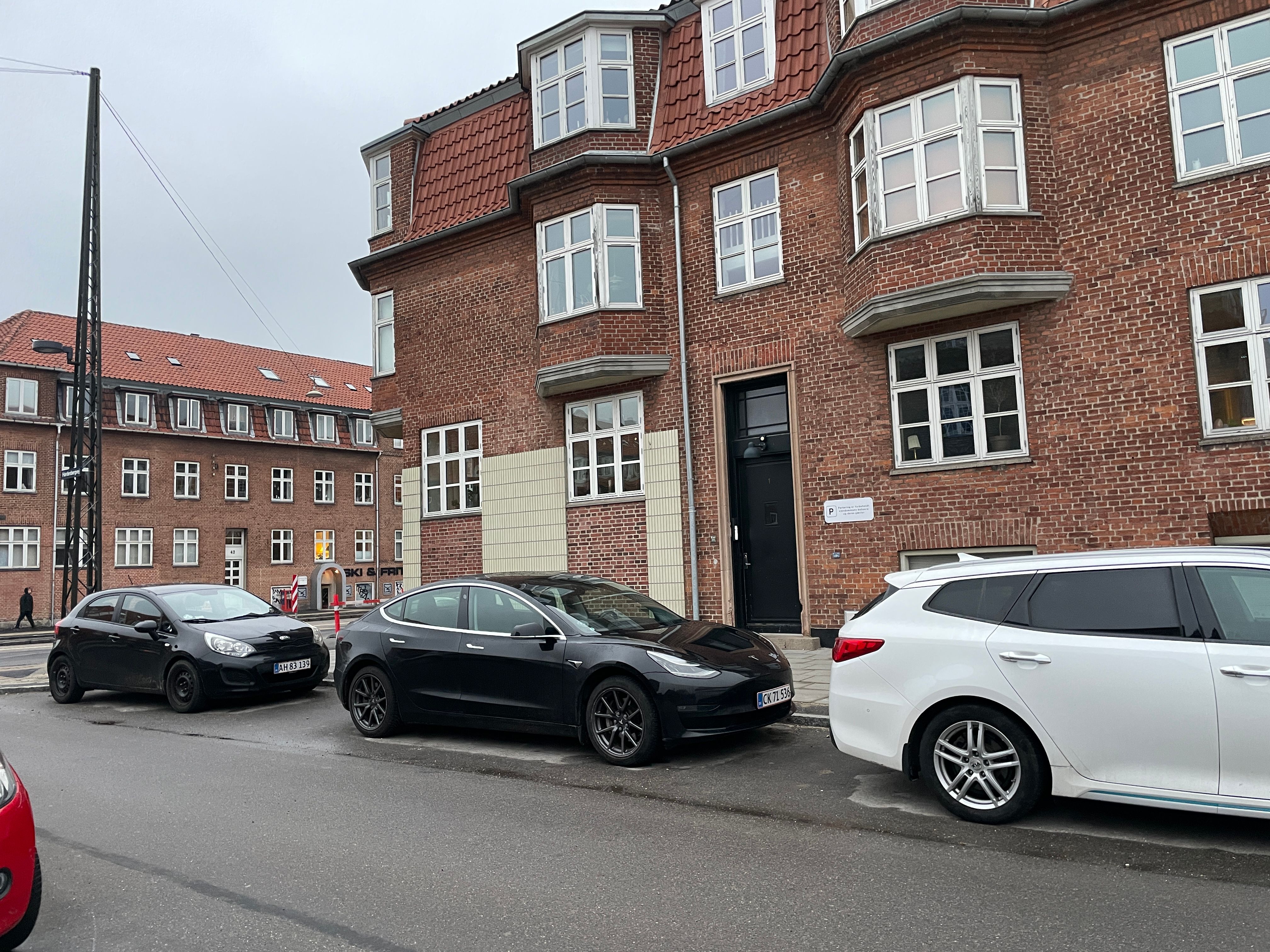 nogle biler holder parkeret på en sidevej i byen