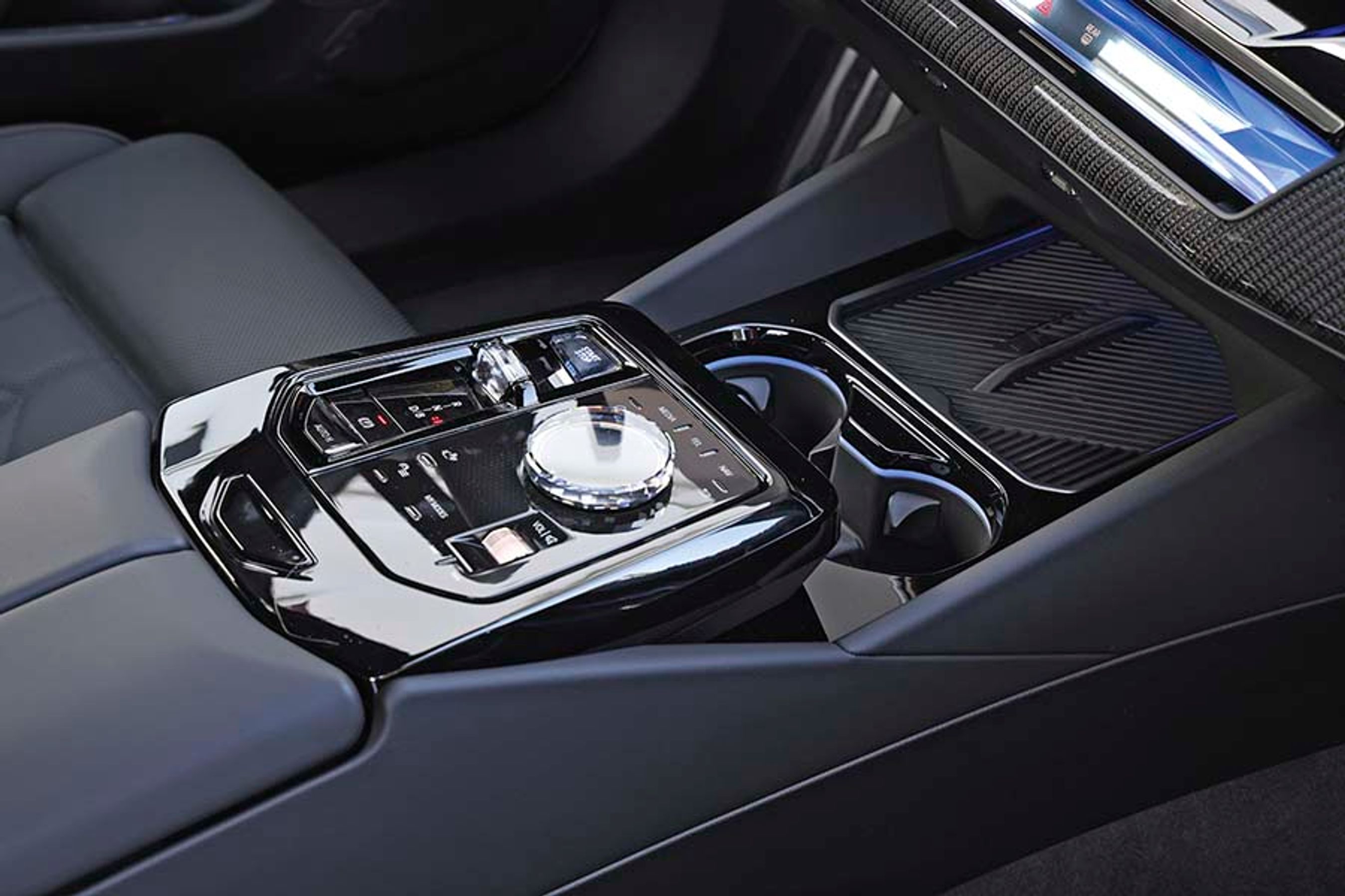 Fra konsollen mellem forsæderne styres bl.a. skærmens menuer fra den store drejeknap. Der er desuden plads til to mobiltelefoner længst fremme.