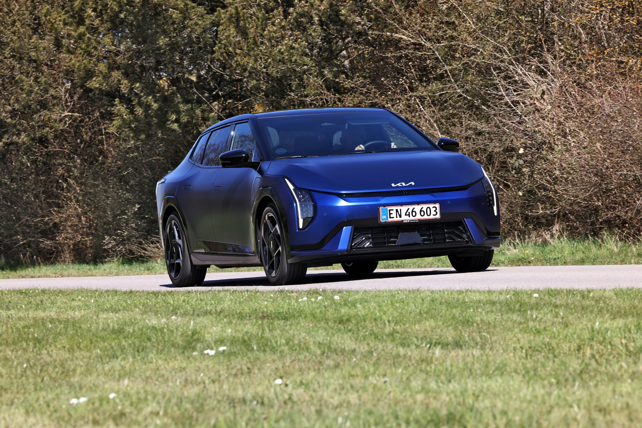 Blå Kia EV4 Fastback 2026 set forfra på en landevej.