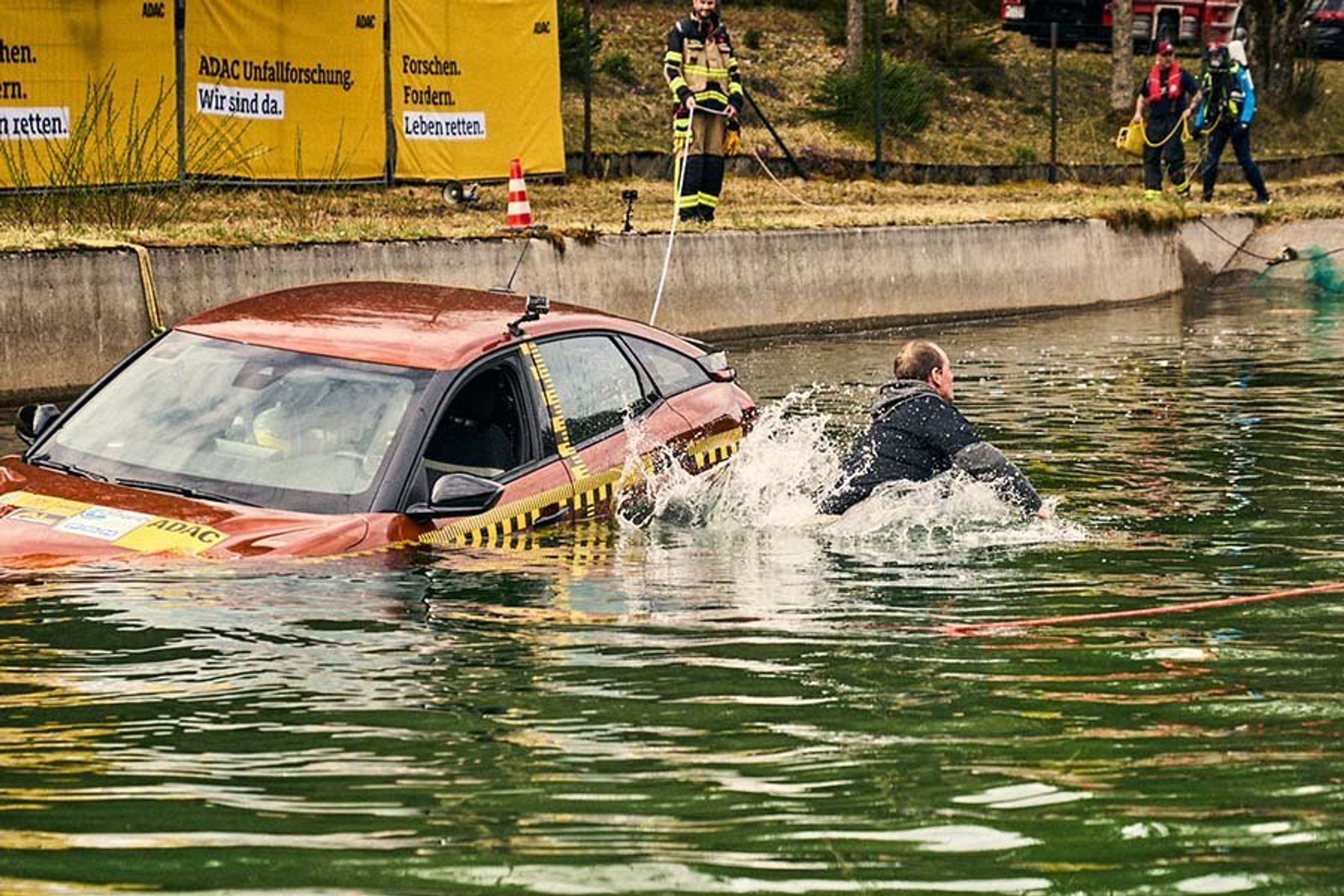 Fører redder sig ud af sideruden i en elbil, der er kørt i vandet