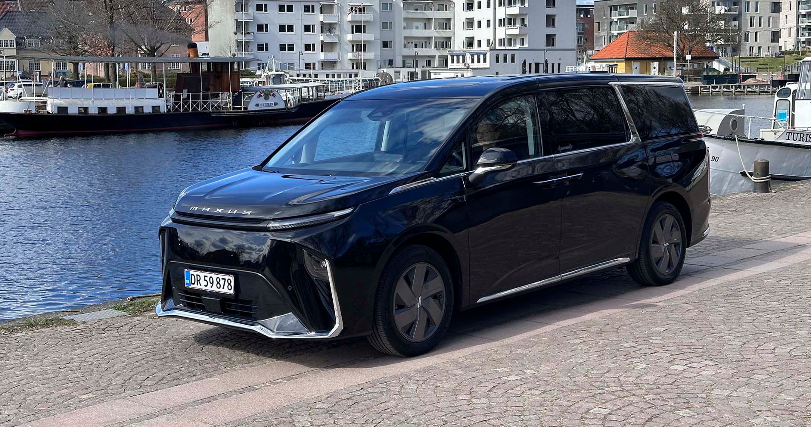 En Maxus Mifa9 holder ved en havn