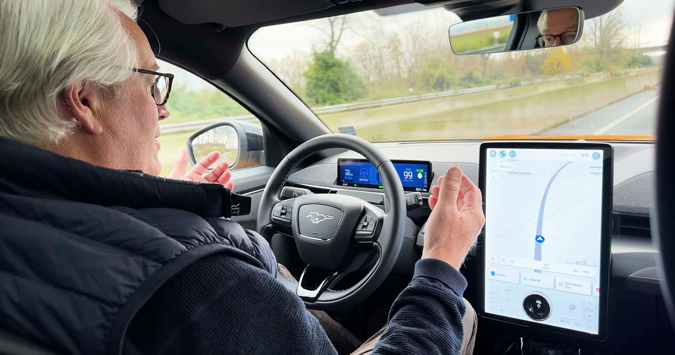 Fører sidder bag rattet uden hænder på rattet, mens bilen kører på motorvej.