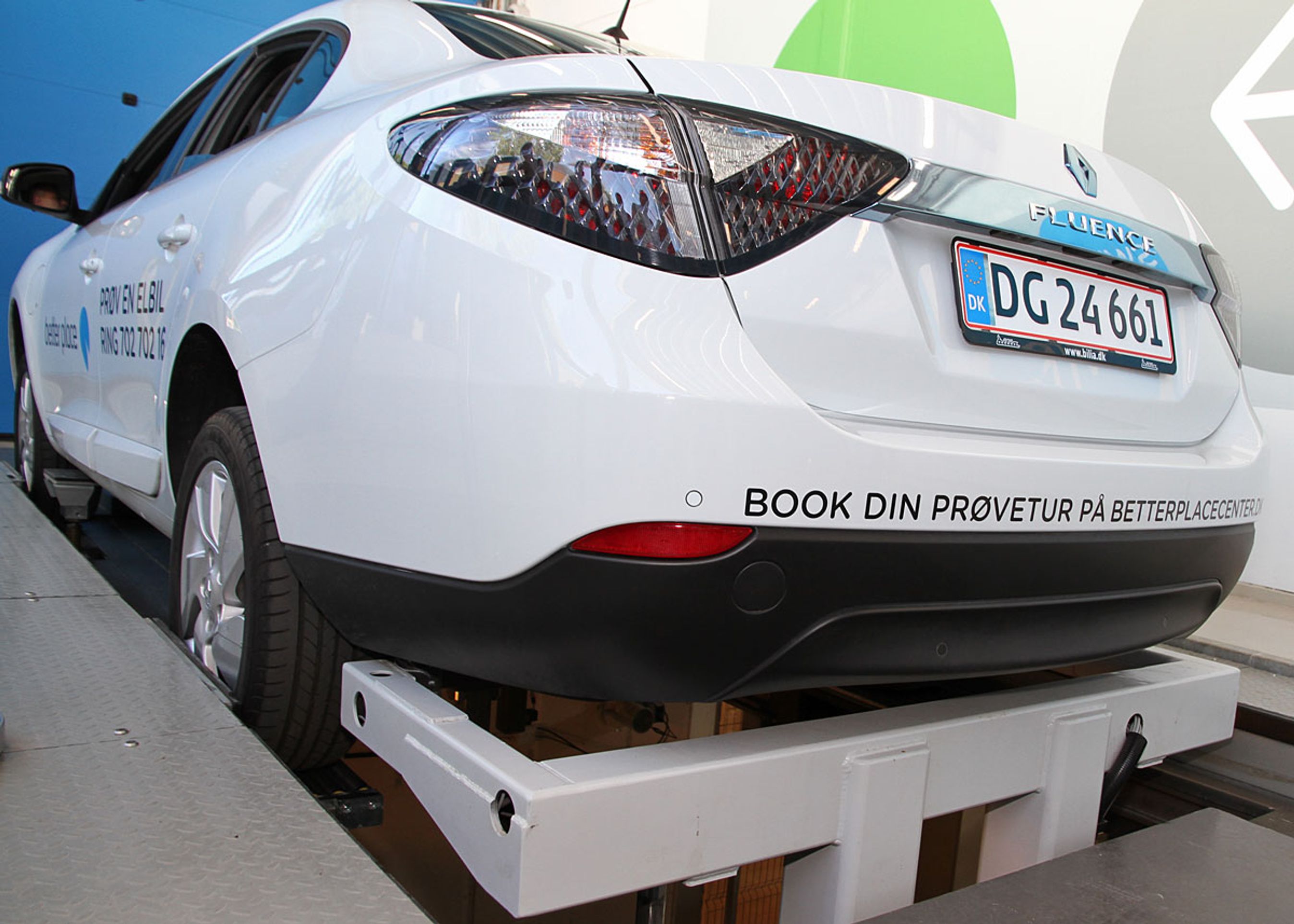 Her er Fluence Z.E. ved at få skiftet batteri. Det eneste, man kan se, er den hvide arm, der holder bilen i et jerngreb, mens batteriet skrues ud og i.