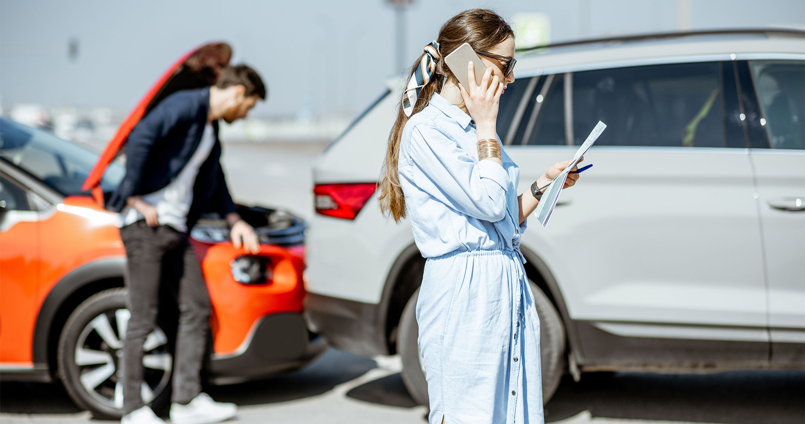 Kvinde taler i mobil efter sammenstød mellem to biler