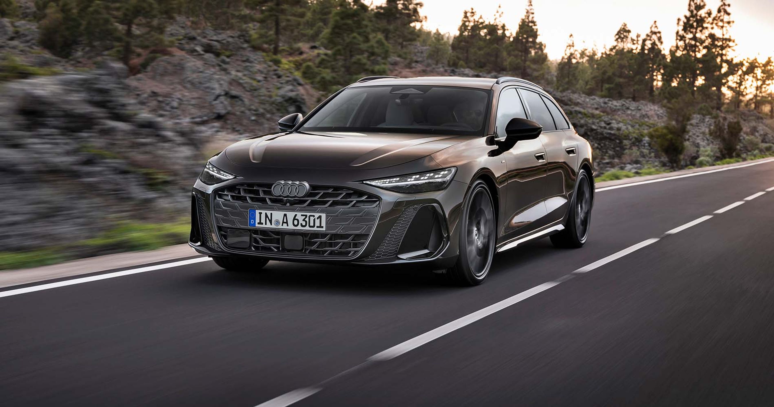 Audi A6 Avant set forfra, mens den køre på vej med klipper i baggrunden