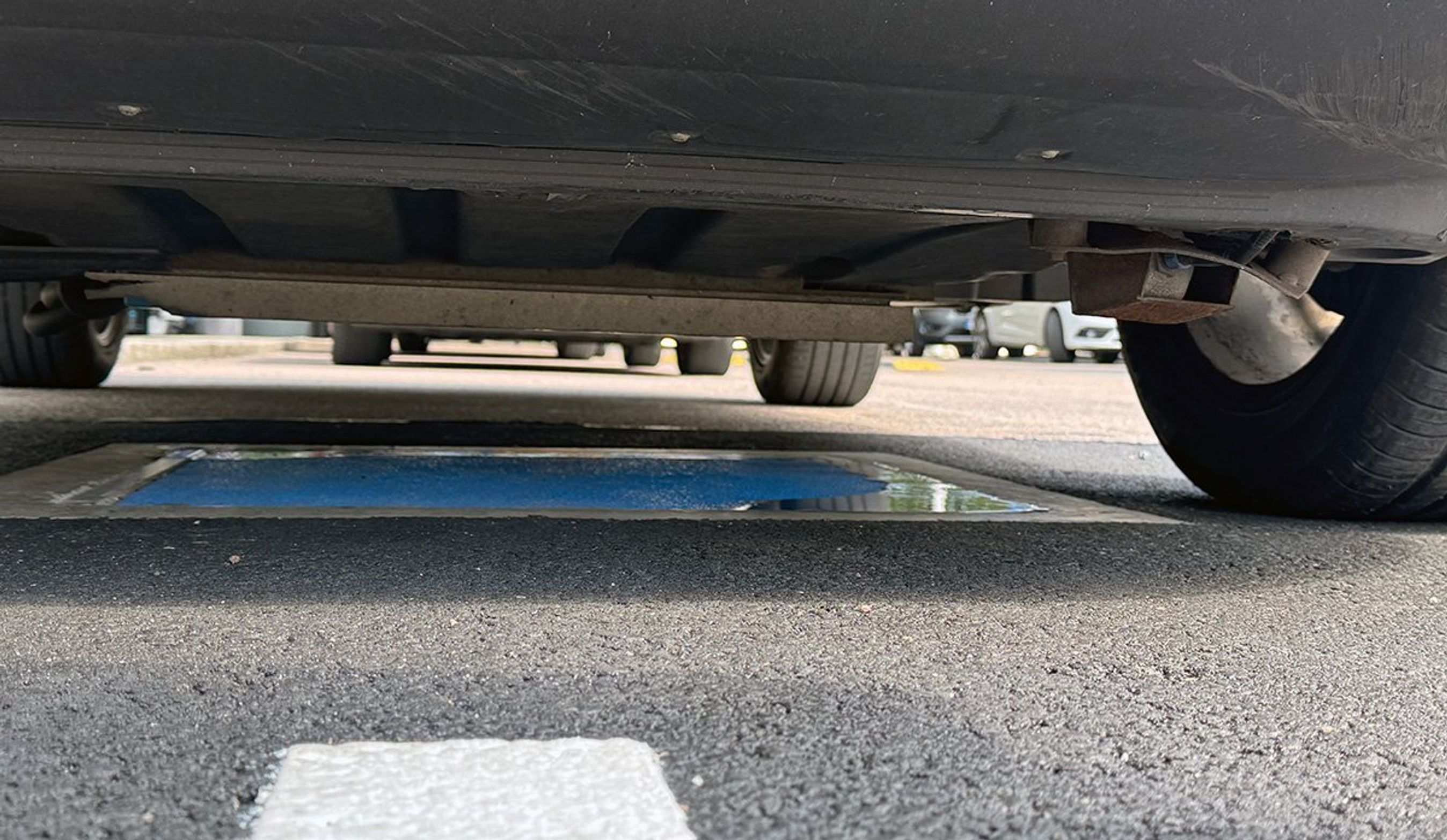 Under bilen sidder strømmodtageren. Den skal ikke sænkes under opladningen.