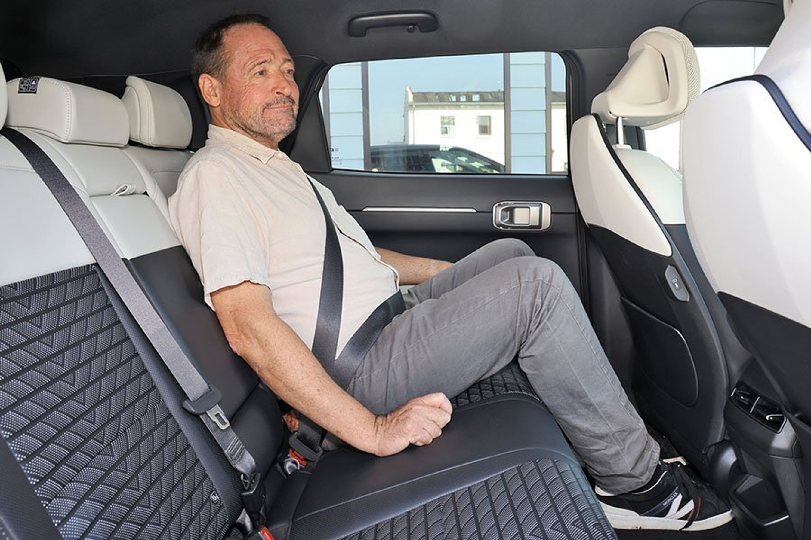 Person sidder på bagsædet i en Kia EV4