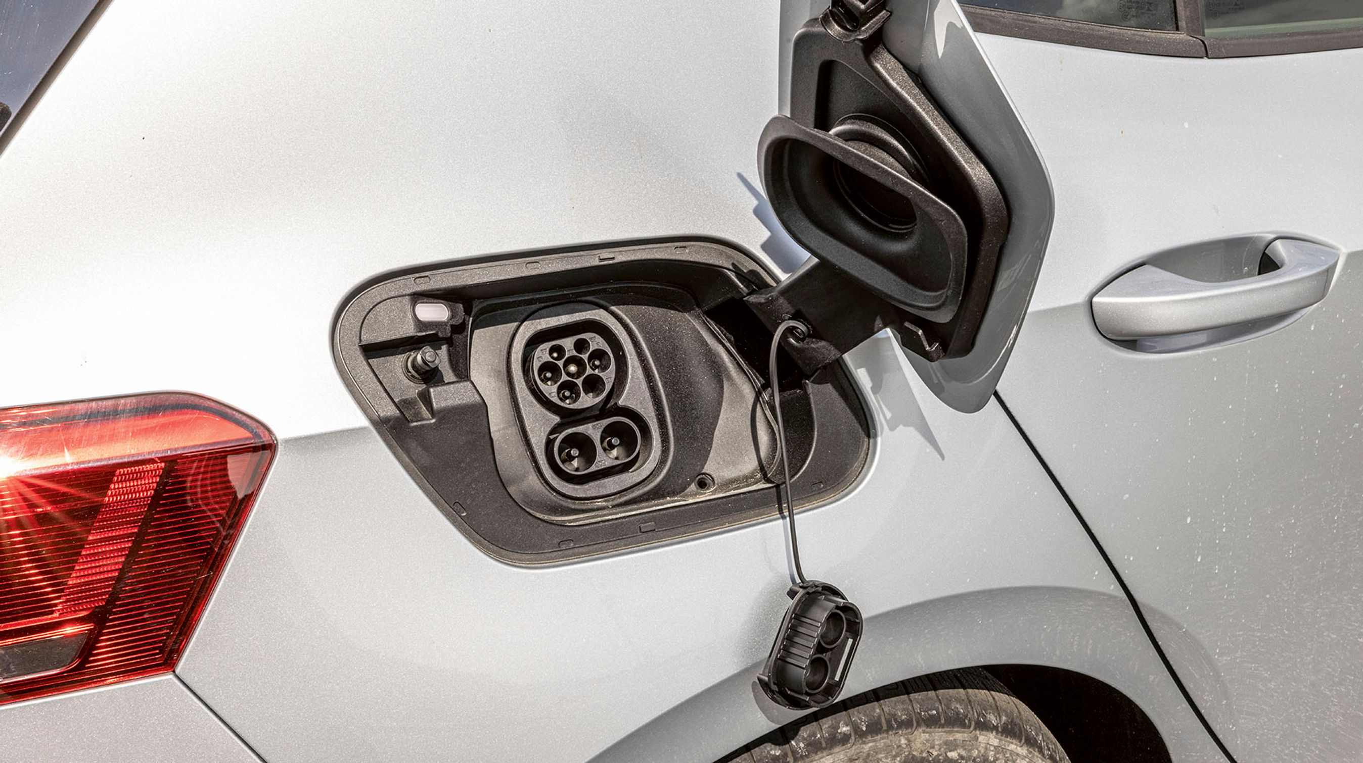 Ladestikket er placeret ved højre baghjul og er dækket af et flot dæksel med indbygget tætning, så man slipper for at rode med plastpropper som på mange andre elbiler. En kontrollampe indikerer ladestatus. Hjemme lader bilen med kun to faser, og det er ikke godt nok.