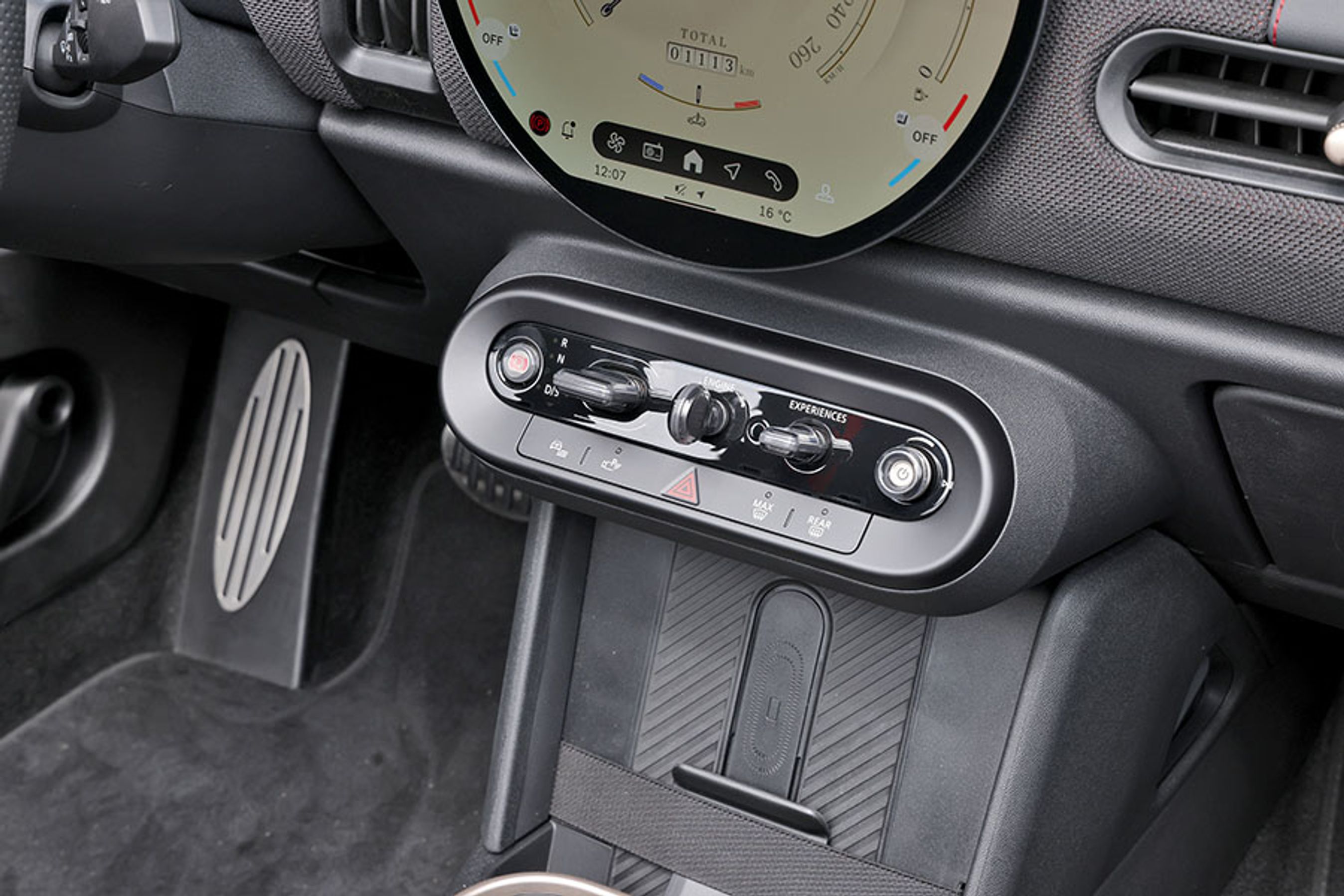 Under skærmen er der placeret en række fysiske knapper, som gør det ud for både en slags startnøgle, en gearvælger og en knap, der skifter mellem de forskellige temaer på skærmen.