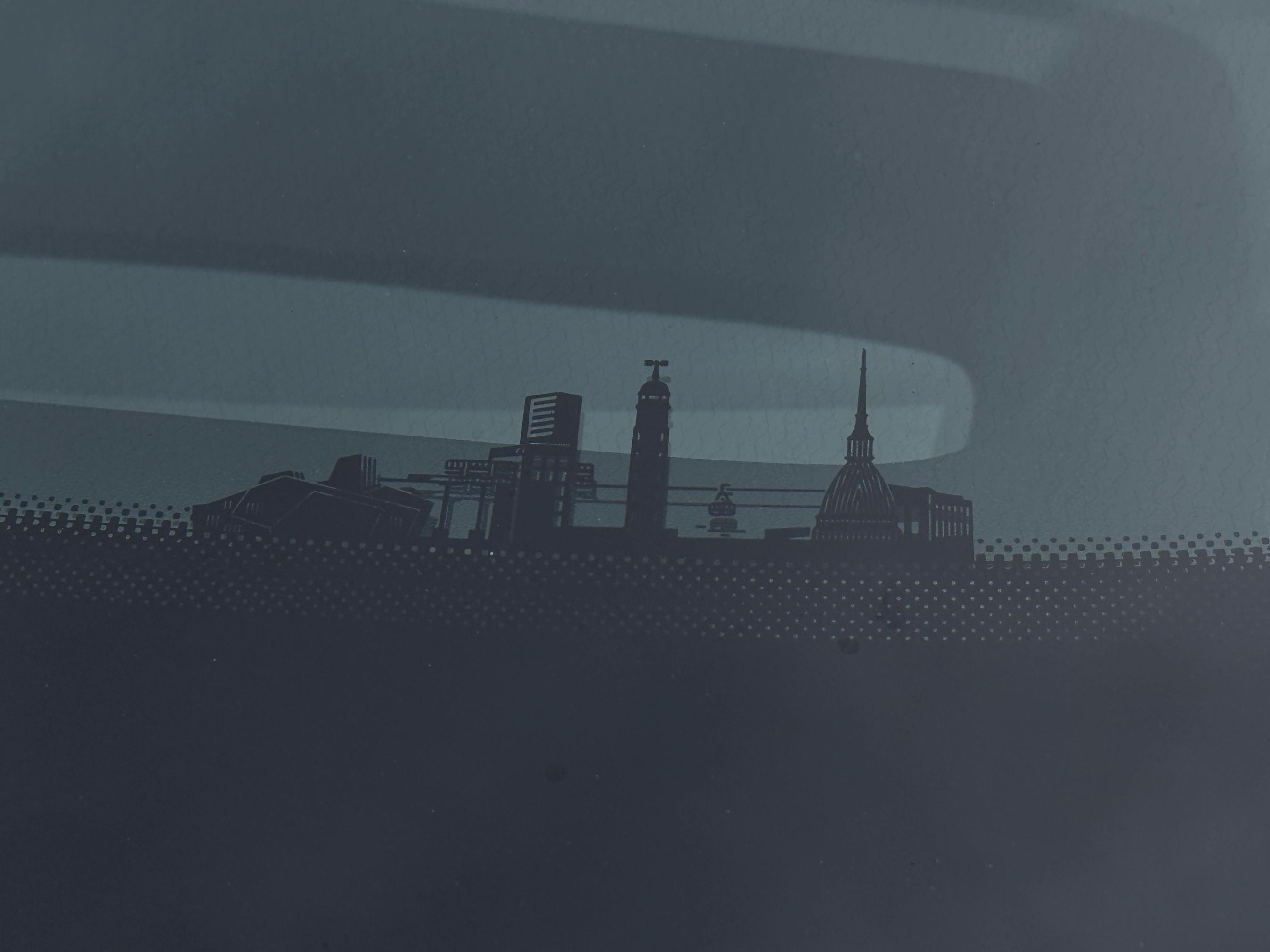 Skyline af kinesisk by og Torino sat sammen som grafik i bunden af ruden i en Changan Deepal S05.