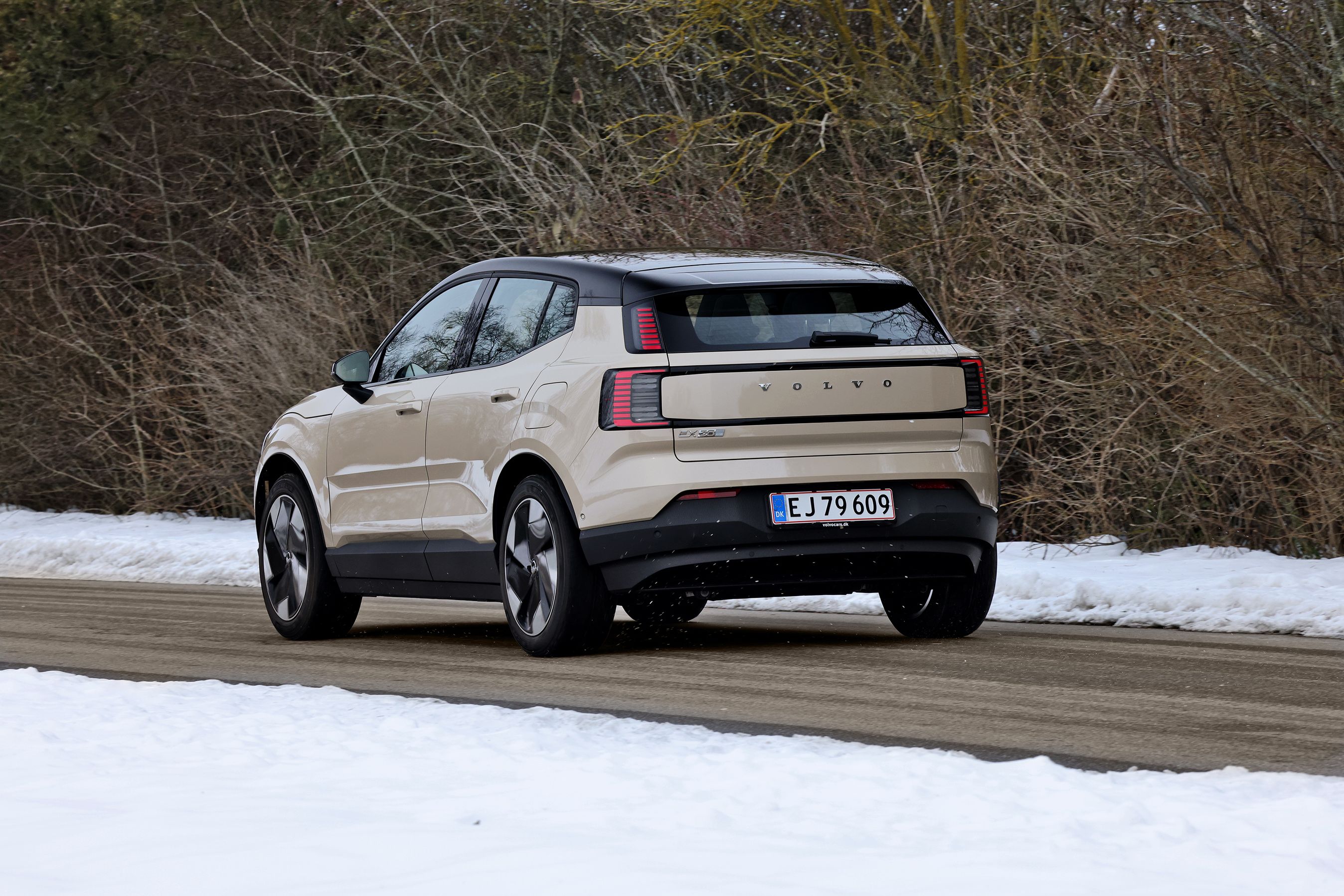 Volvo EX30 set bagfra, mens den kører på landevej med sne omkring
