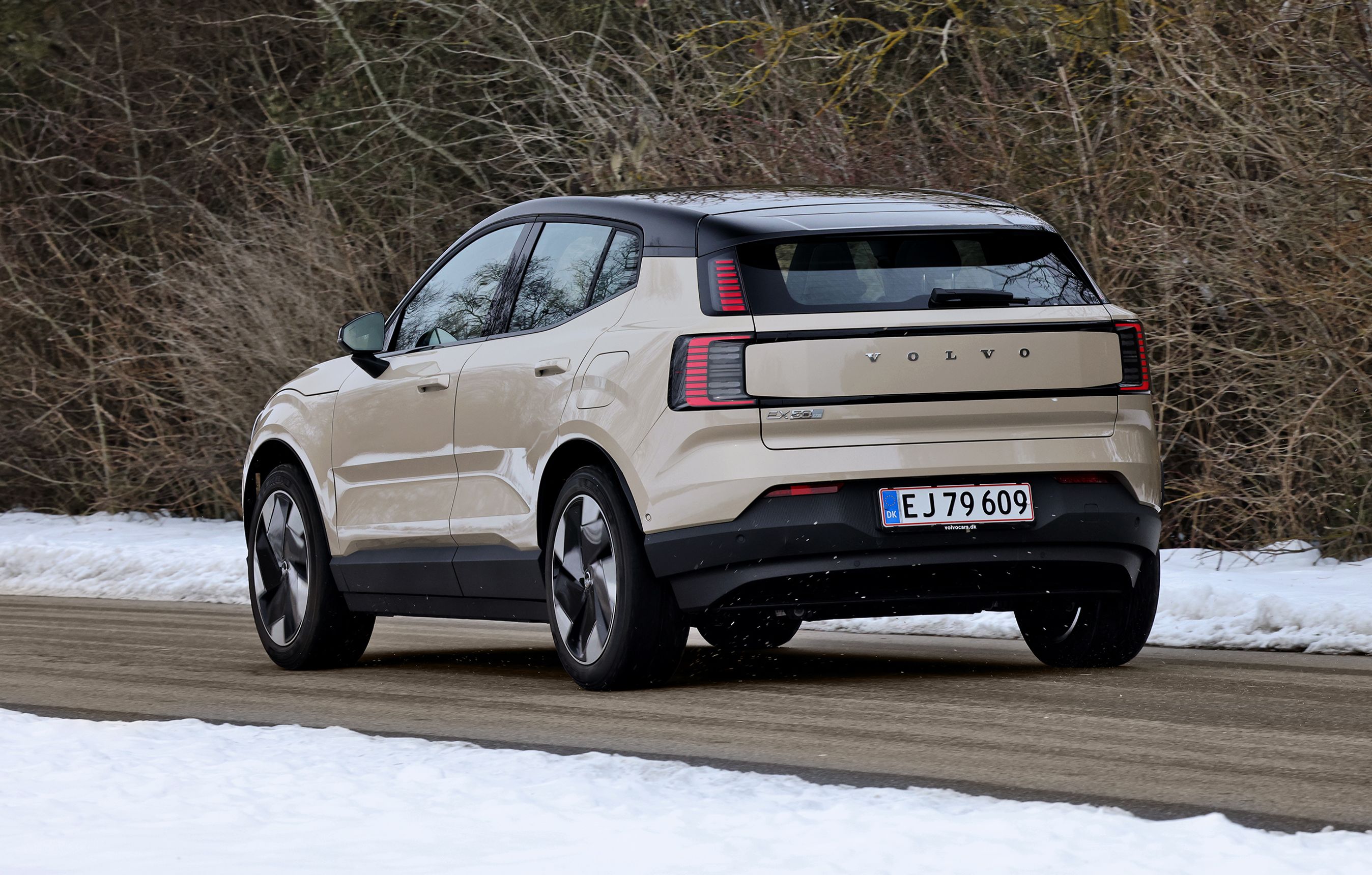 Volvo EX30 set bagfra, mens den kører på landevej med sne omkring