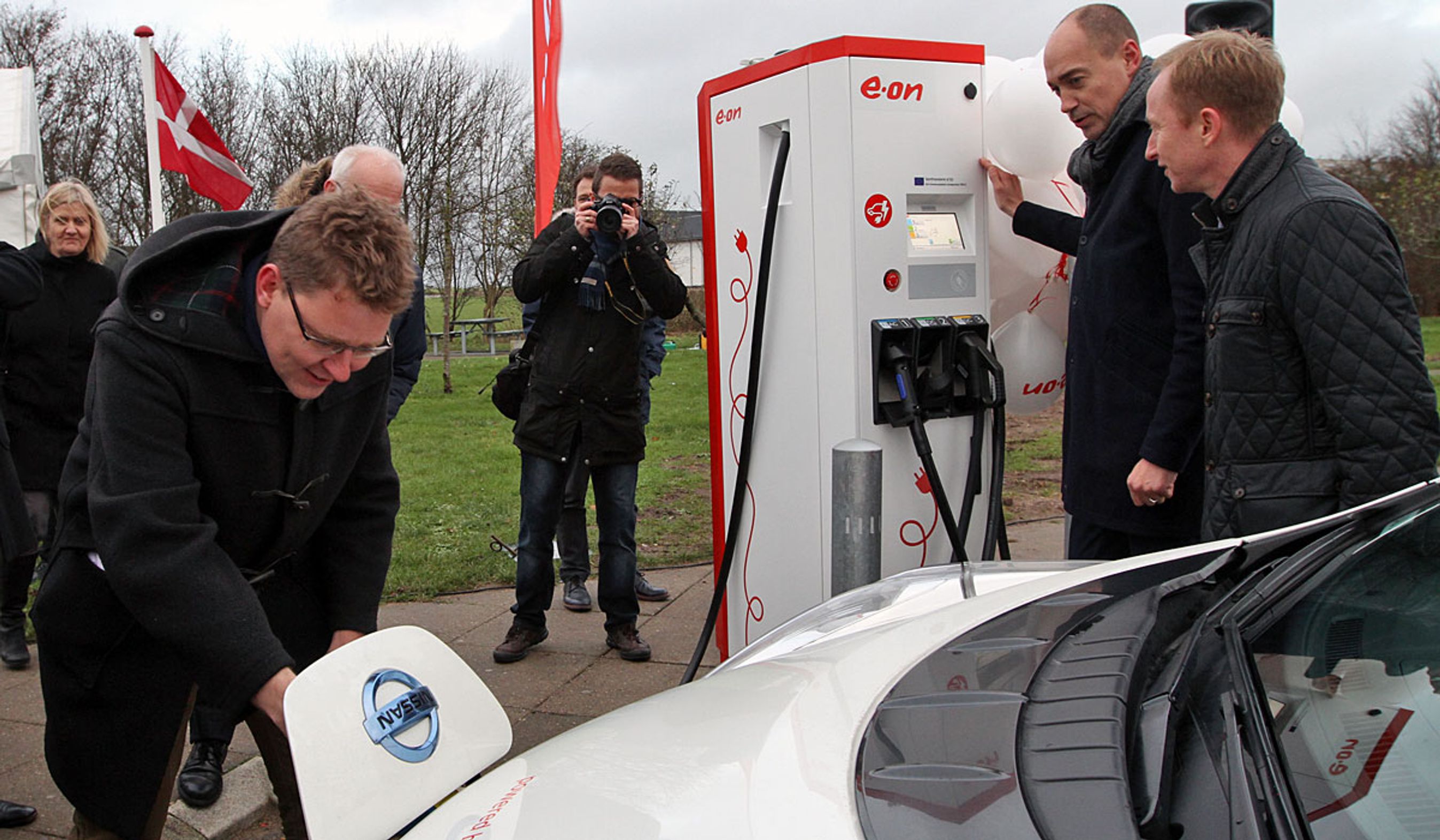 To ministre hjalp hinanden med at starte ladningen af den første bil.