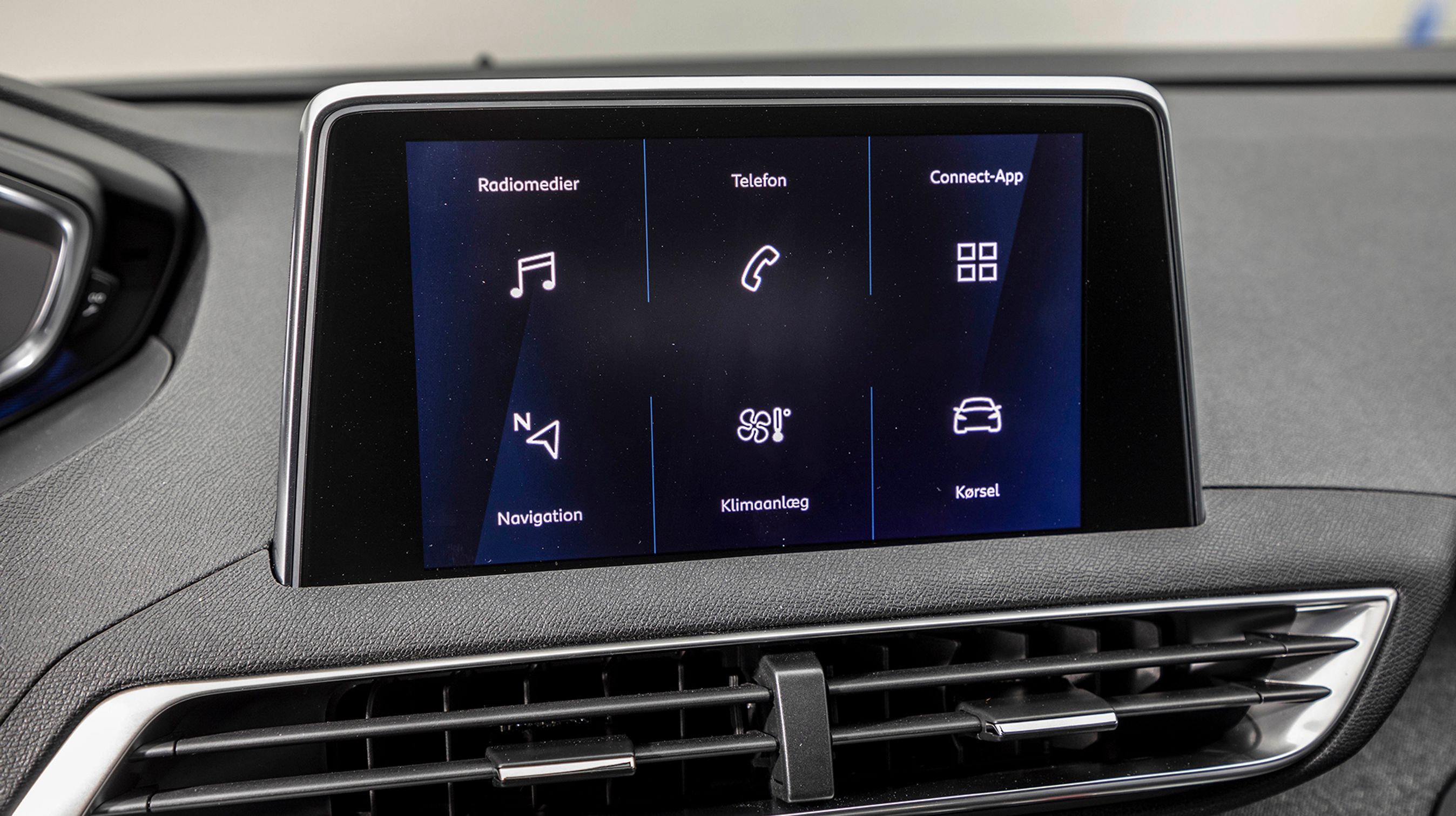 Skærmen i midten stikker op af instrumentbordet. Der er danske menuer, og Apple CarPlay er standard.