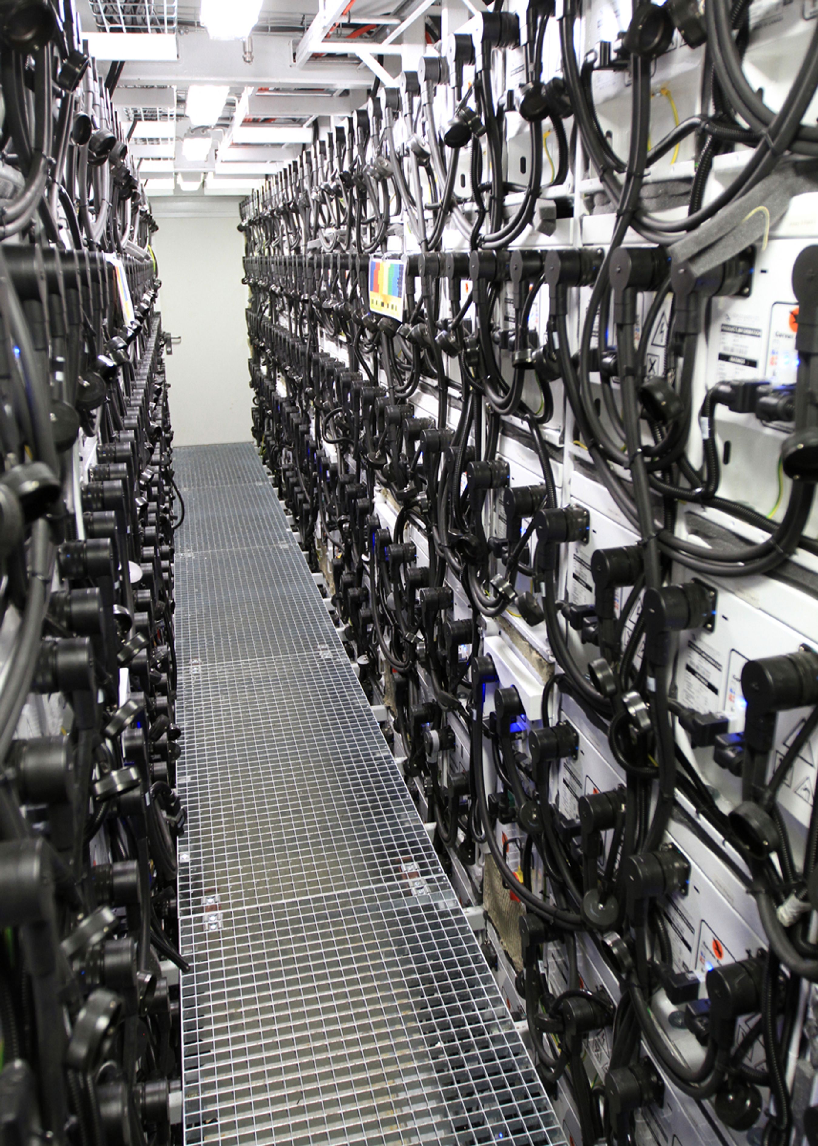 399 litium-batterier á 6,5 kWh er stablet op i flere meters højde. Der er tre lag under gangbroen.