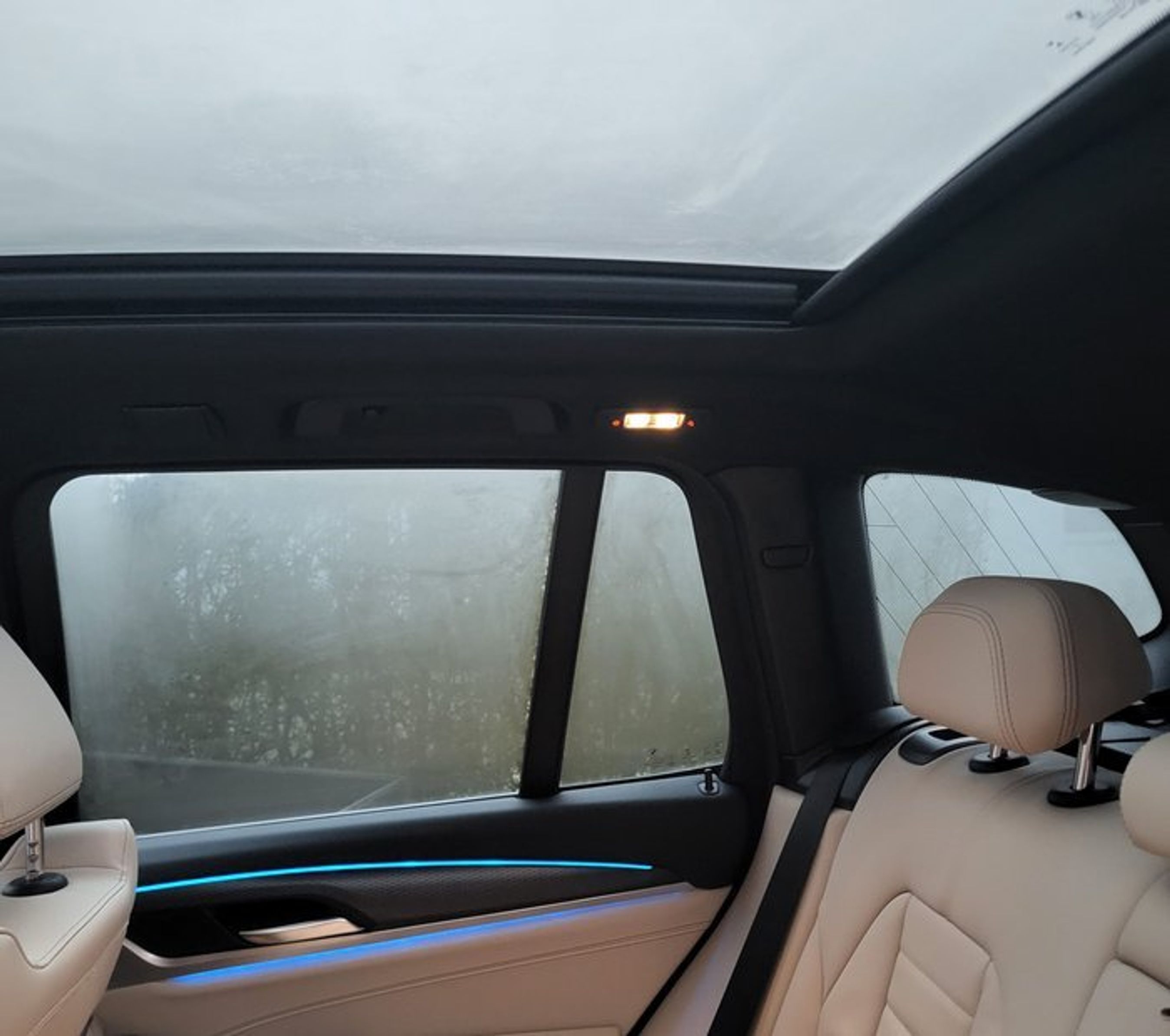 Bil med duggede ruder og soltag set fra bagsædet