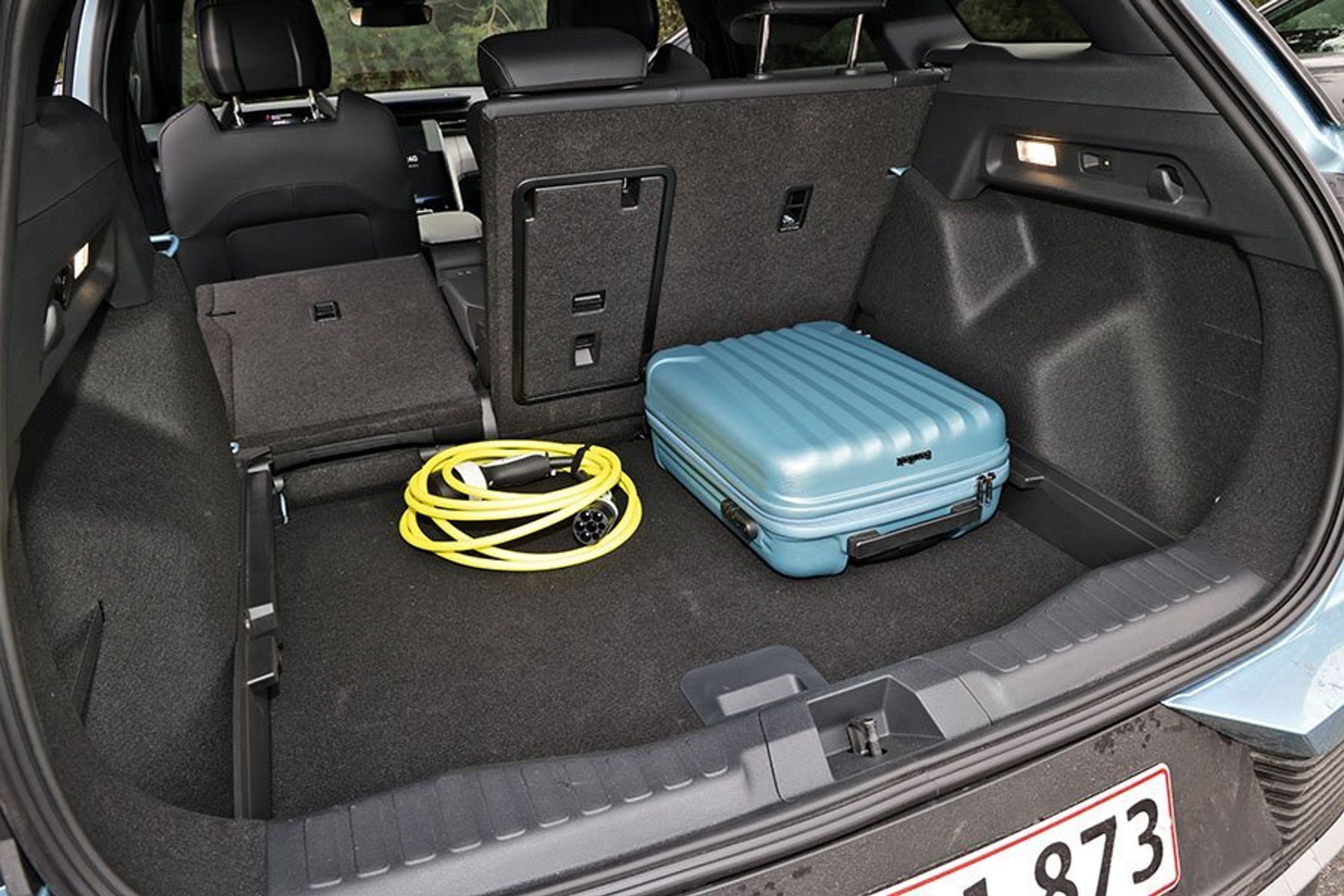 Bagagerum med kuffert og ladekabel i en Ford Explorer