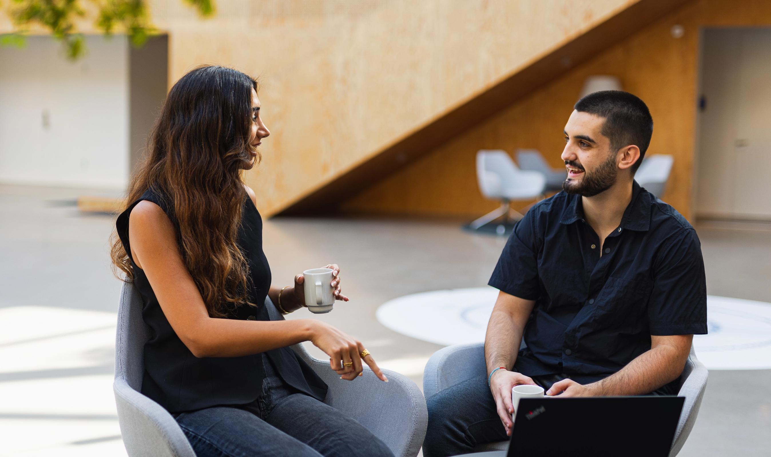 To FDM medarbejdere taler sammen ved et mødebord