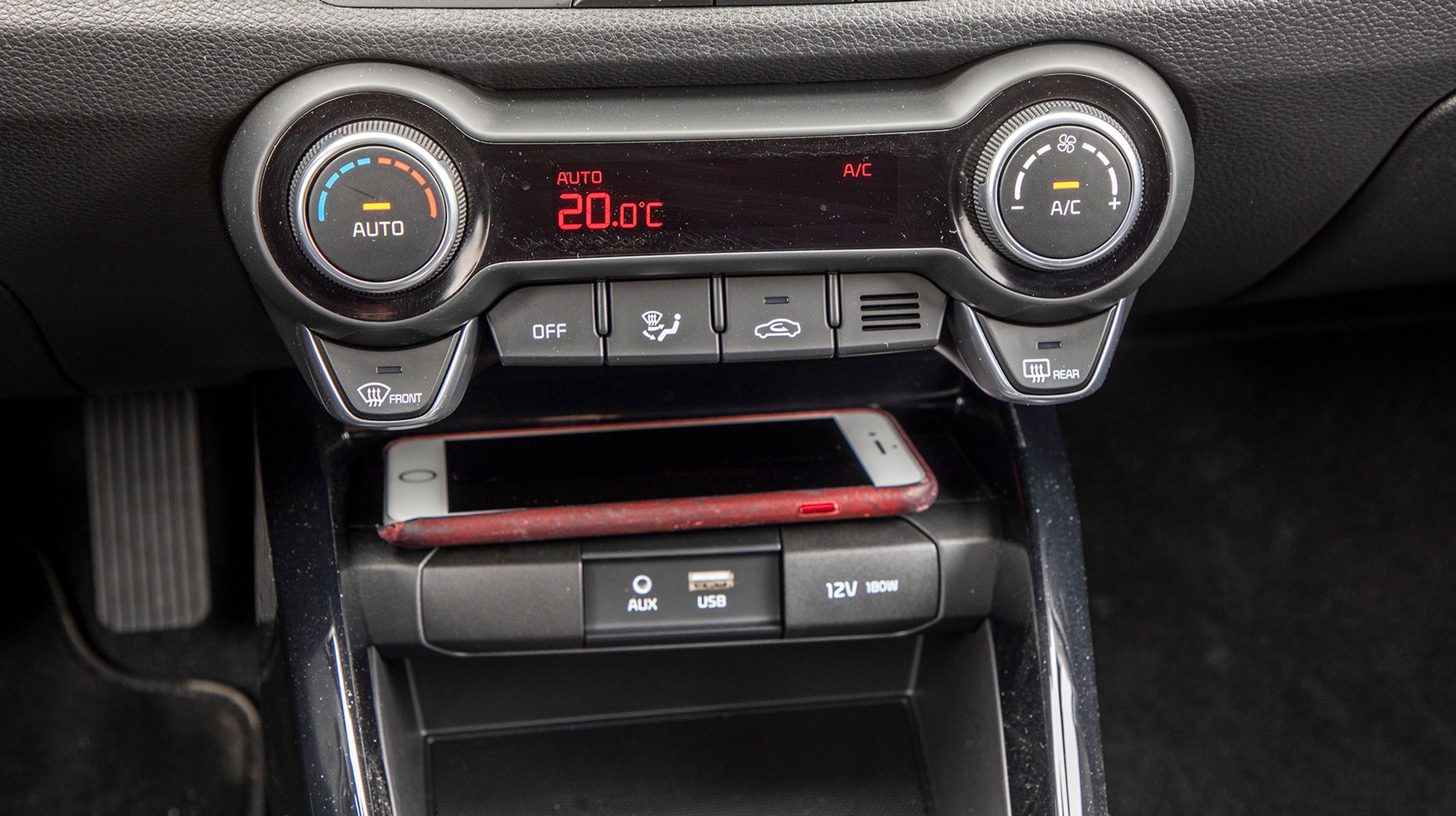 Der er letbetjente drejeknapper til varme- og ventilationsanlægget. Nedenfor findes en hylde til mobiltelefonen.