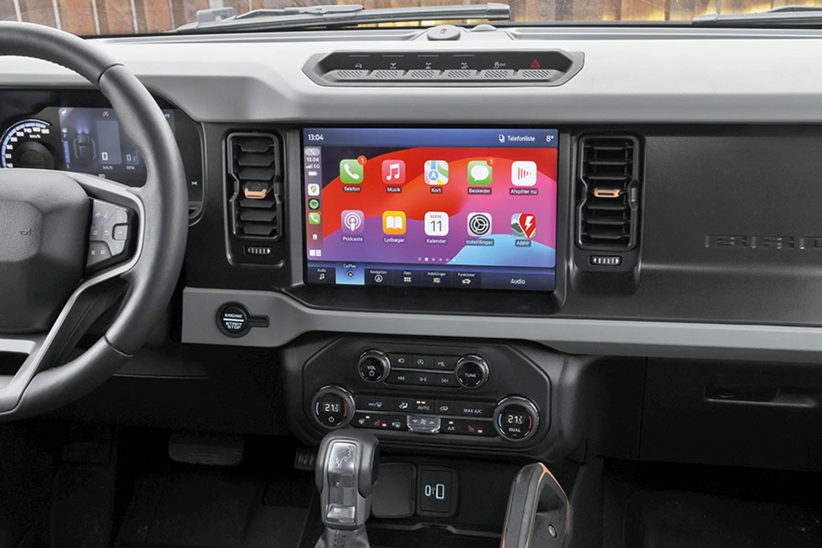 Den store skærm i midten er en trykskærm med mange menuer, der alle er på dansk. Over skærmen er der knapper til styring af firehjulstrækket.