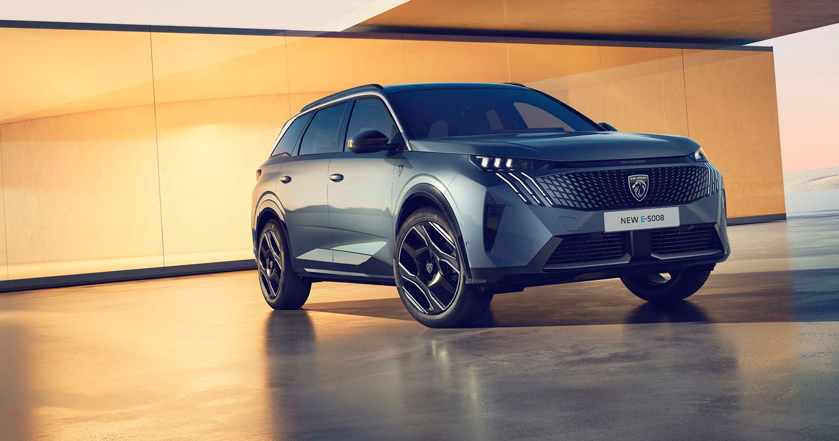 Peugeot E-5008 elbilen står med en elegant bygning i baggrunden.