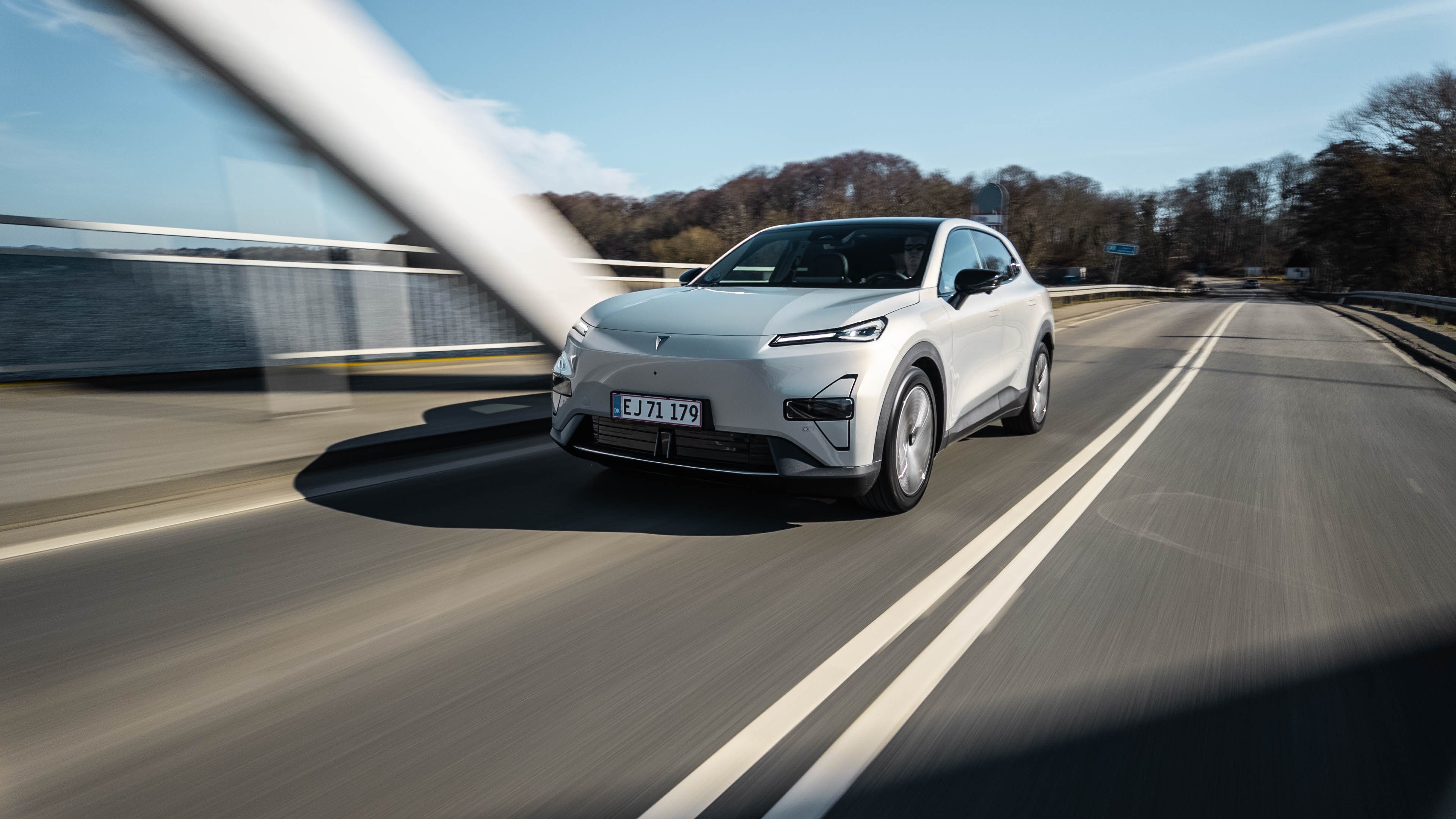 Changan Deepal S05 i sølvfarve med en bro i baggrunden. 