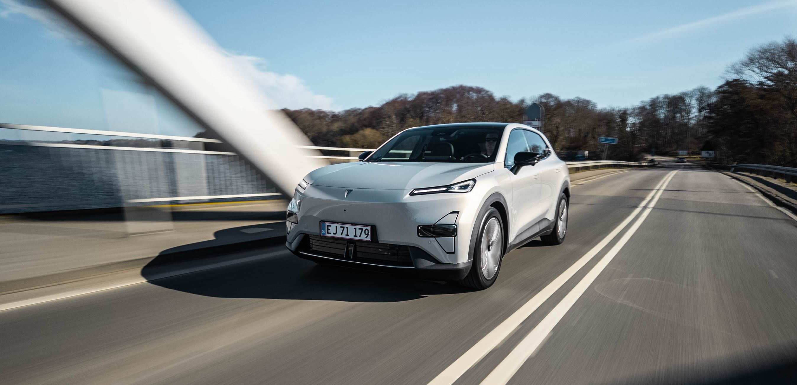 Changan Deepal S05 i sølvfarve med en bro i baggrunden.