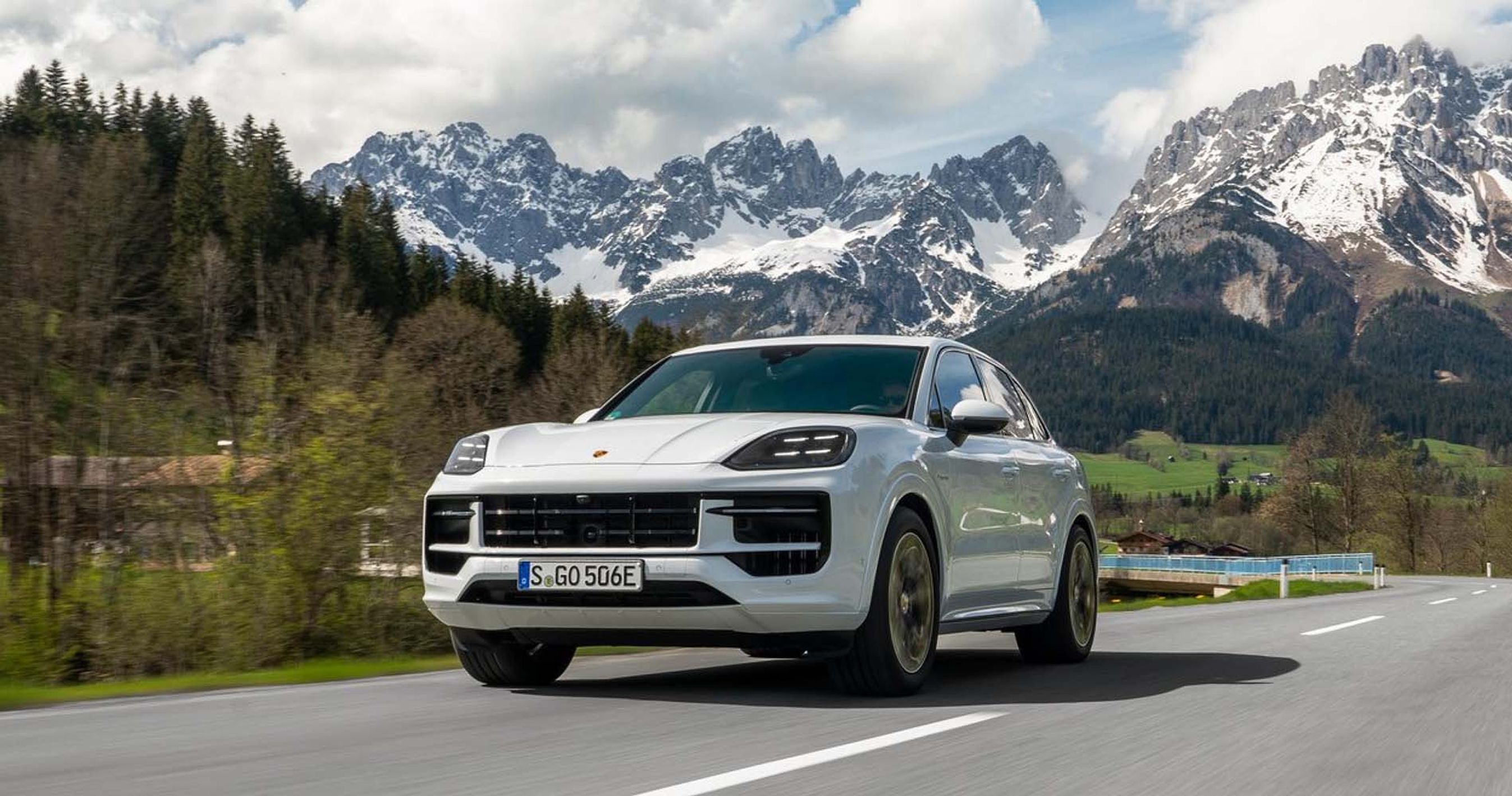 HVis Porsche Cayenne i fart på landevej med bjerge i baggrunden