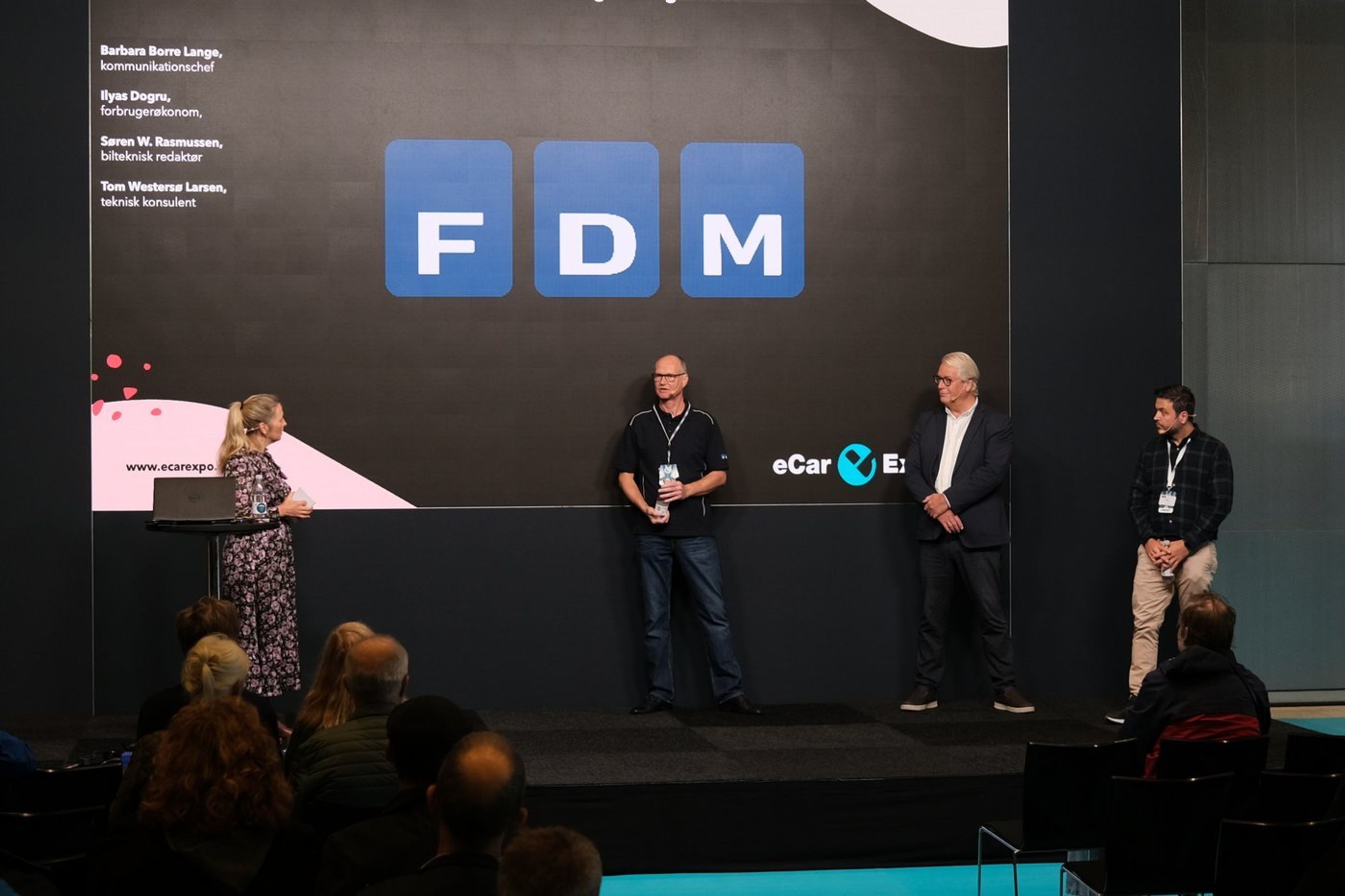 FDMs medarbejdere står på scenen under eCarExpo.