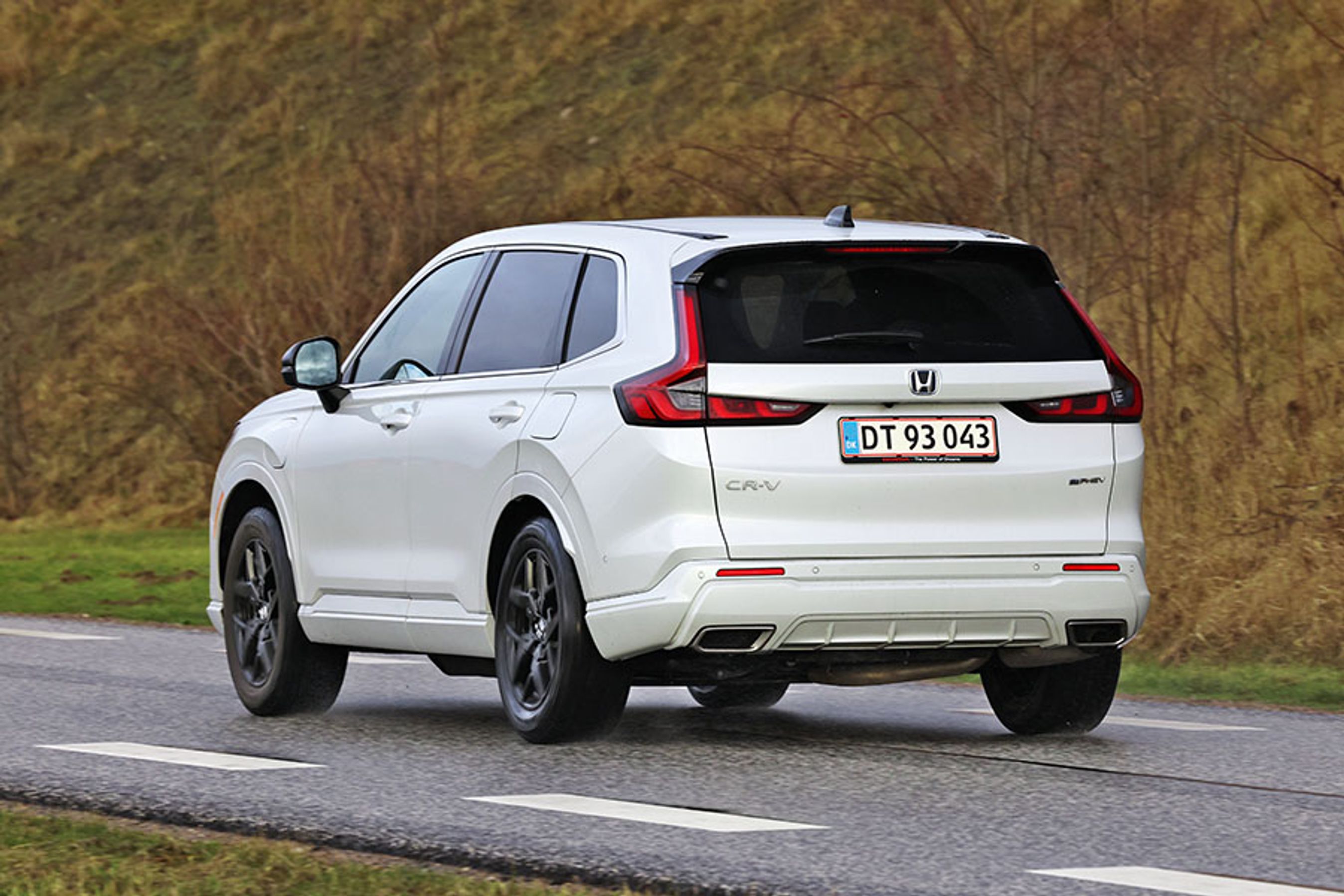 Hvid Honda CR-V set bagfra, mens den kører på landevej