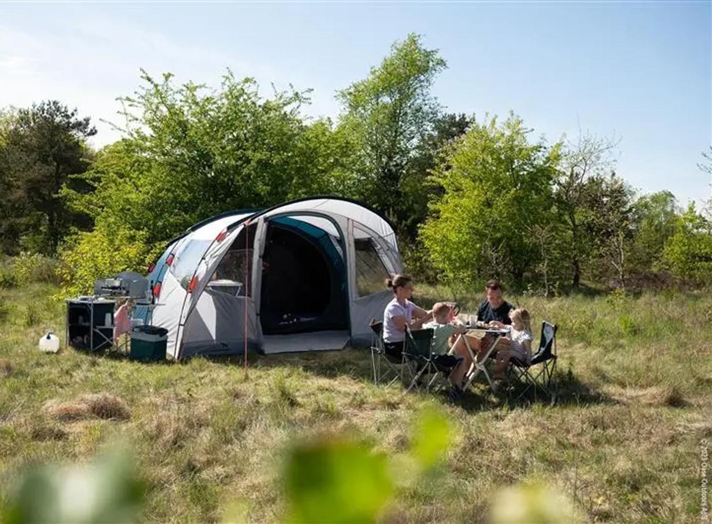 Familie er på camping i det grønne græs