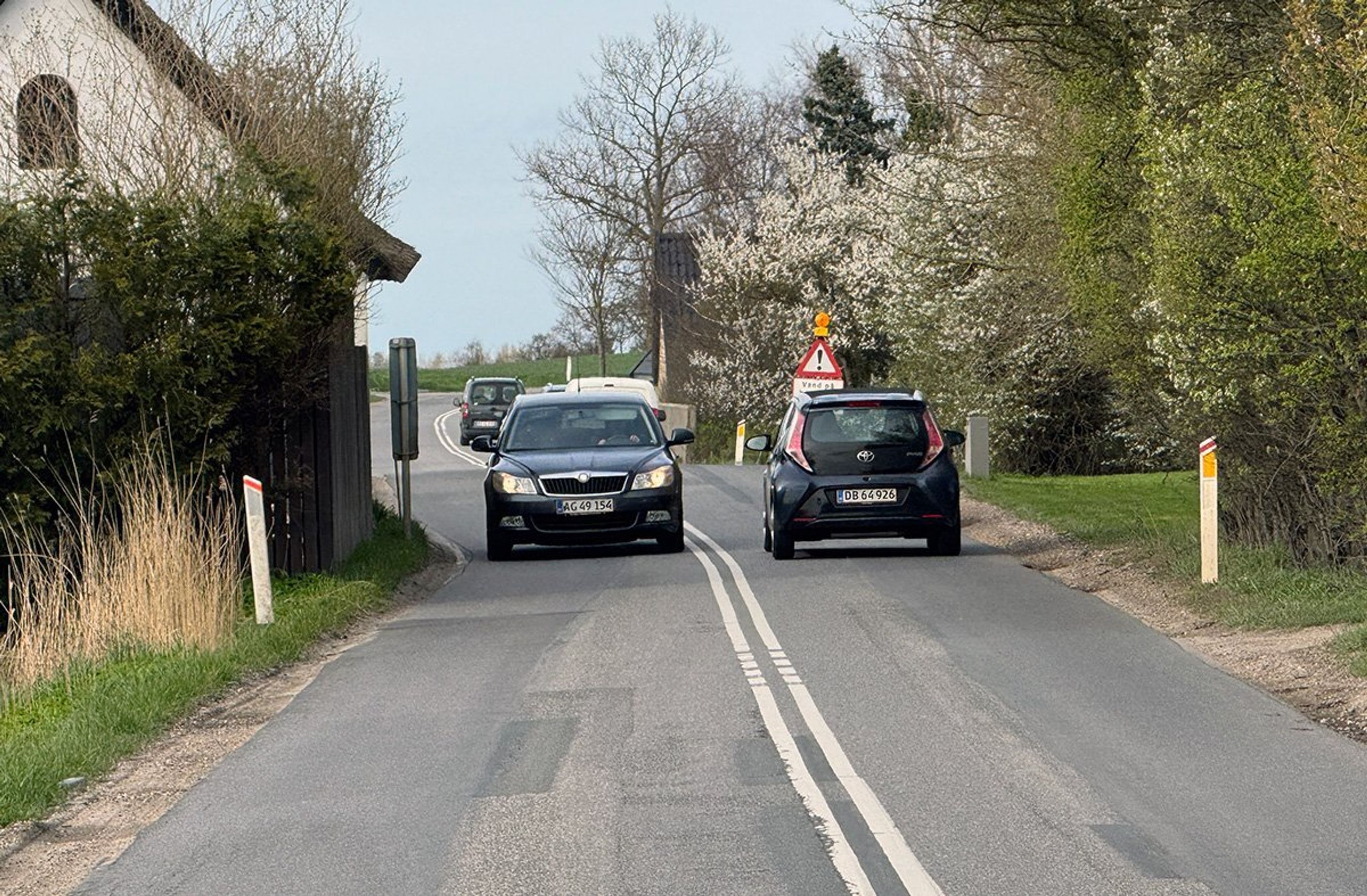 Smal landevej mellem huse.