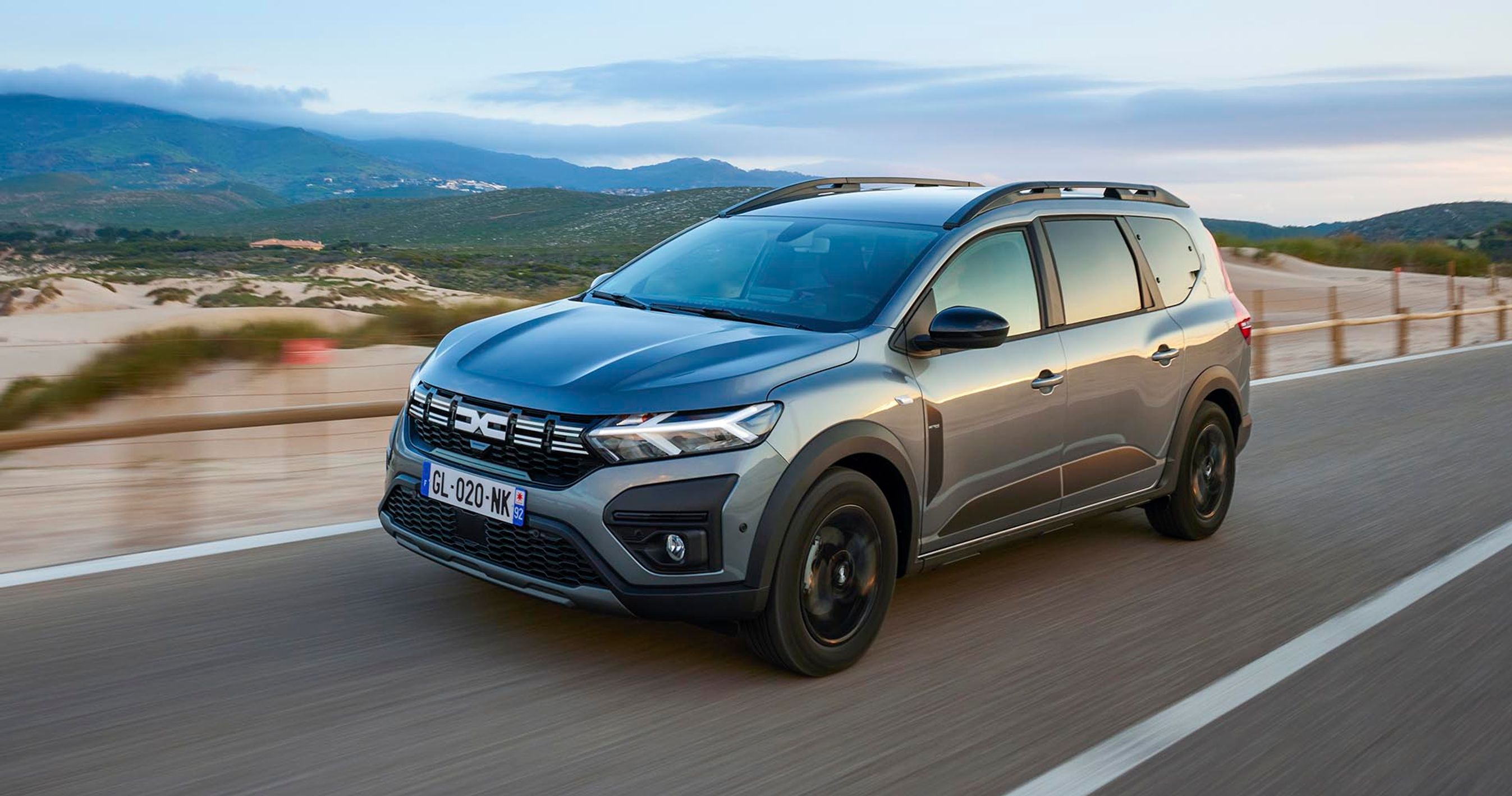 Dacia Jogger kører på landevej med skyet himmel i baggrunden