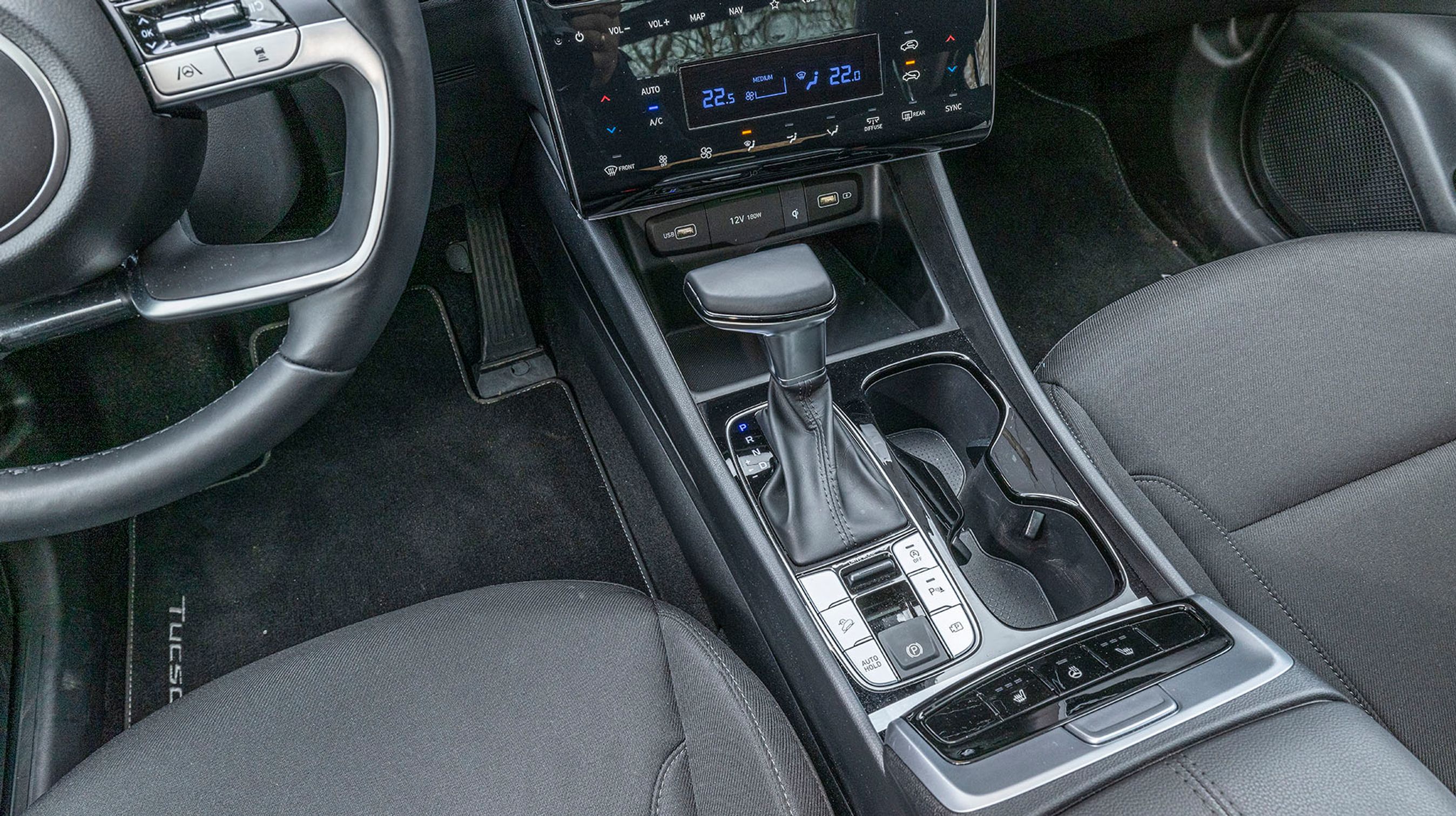 Der er fine kopholdere ved siden af gearstangen, og bagude er der knapper til sæde- og ratvarme, der er samlet i en gruppe.