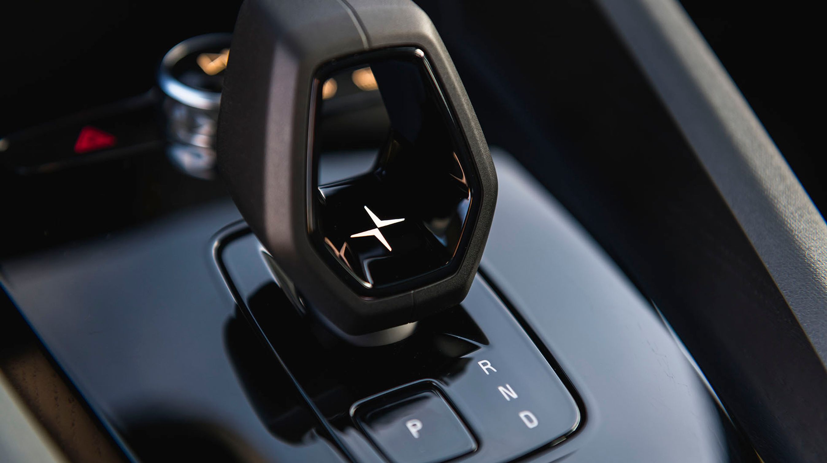 Fra den sjove gearvælger mellem forsæderne vælger man kørselsretningen. I midten ses et lysende Polestar-logo.