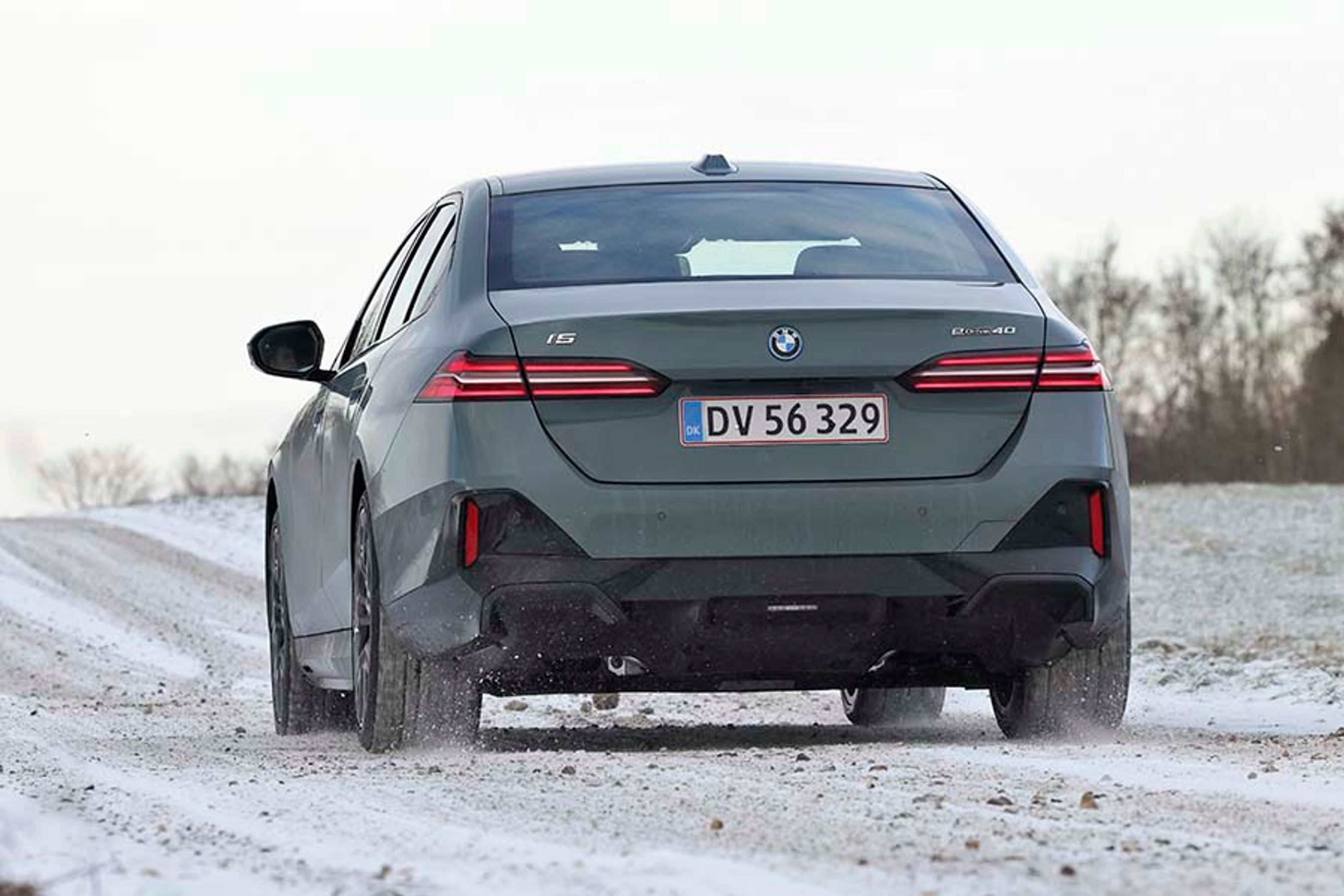 Elbilen BMW i5 set bagfra, mens den kører på en snedækket vej.
