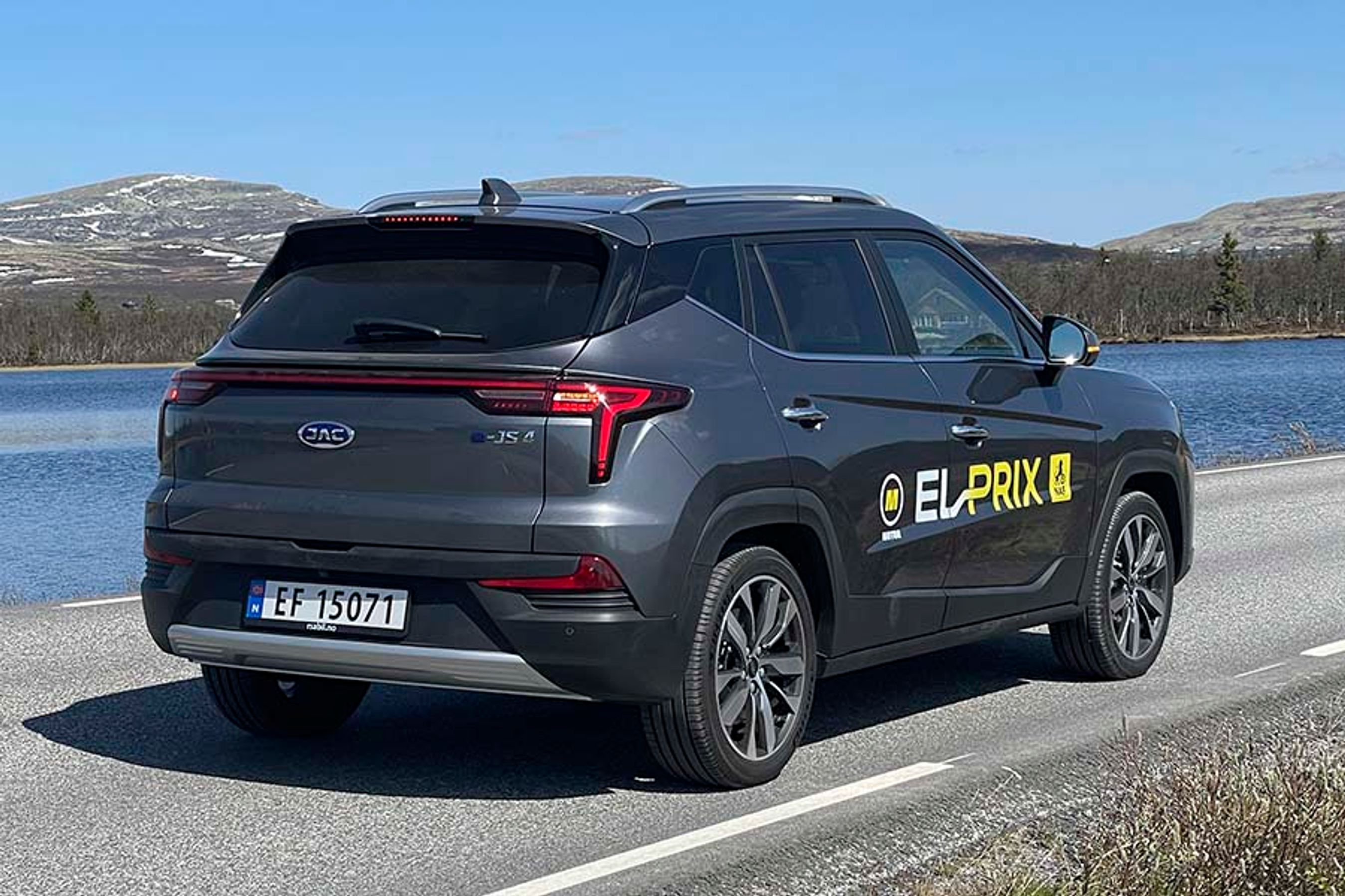 Elbilen JAC e-JS4 set bagfra, mens den holder ved en norsk skovsø
