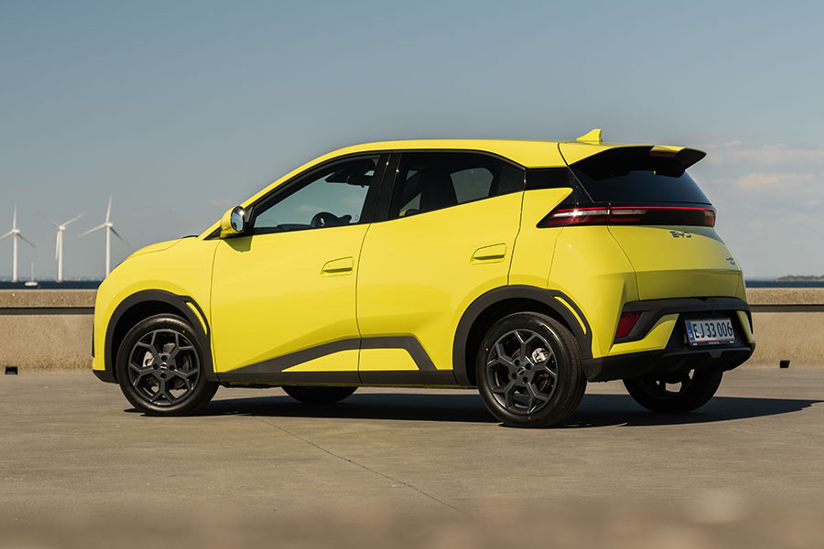 BYD Dolphin Surf set bagfra med vindmøller i baggrunden
