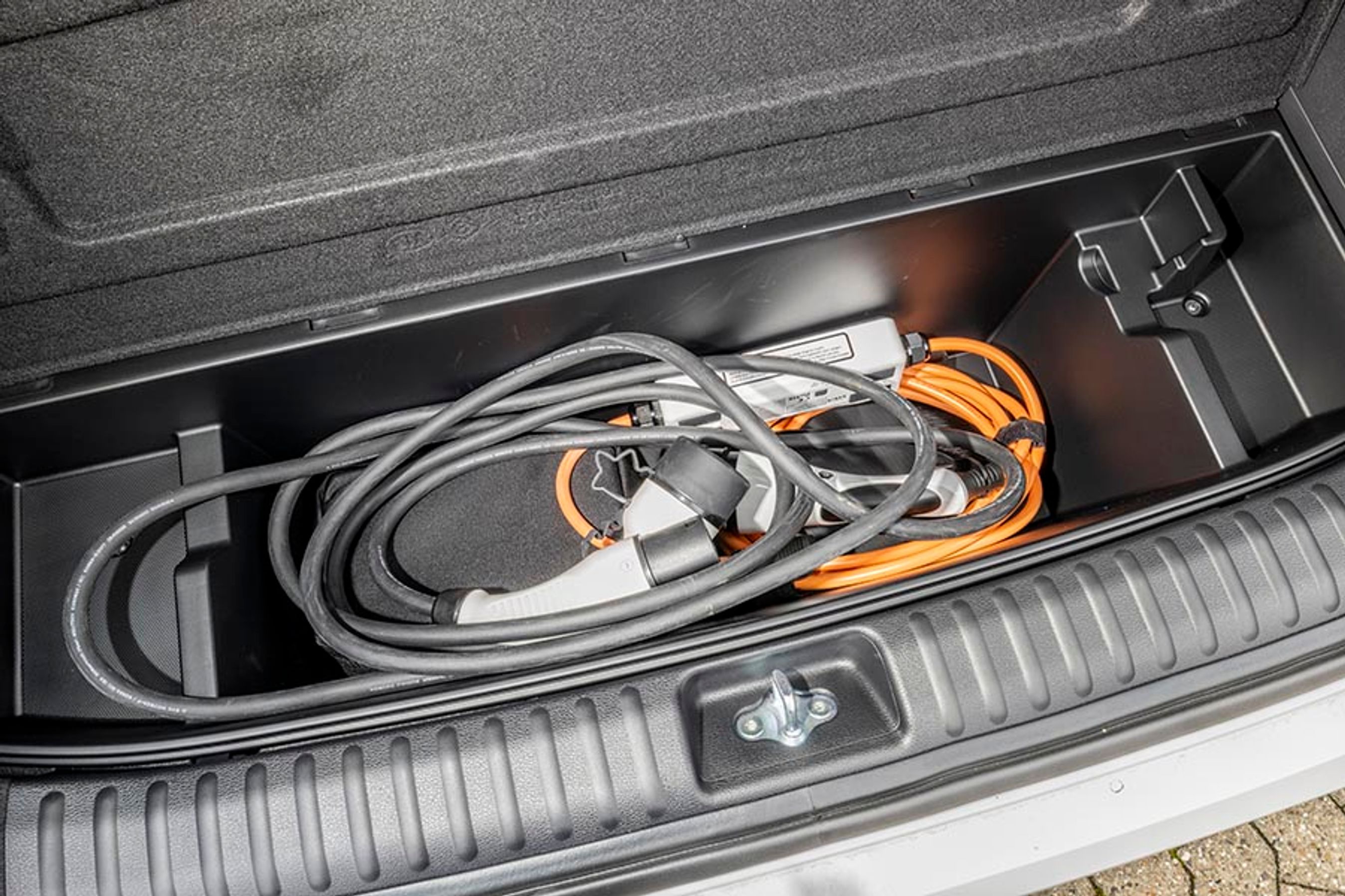 Under selve bagagerummet er der flere mindre rum. Det største af dem ligger tættest på kofangeren, og her er der god plads til både nødlader og ladekabler, omend placeringen ikke er optimal i en pakket feriebil. 