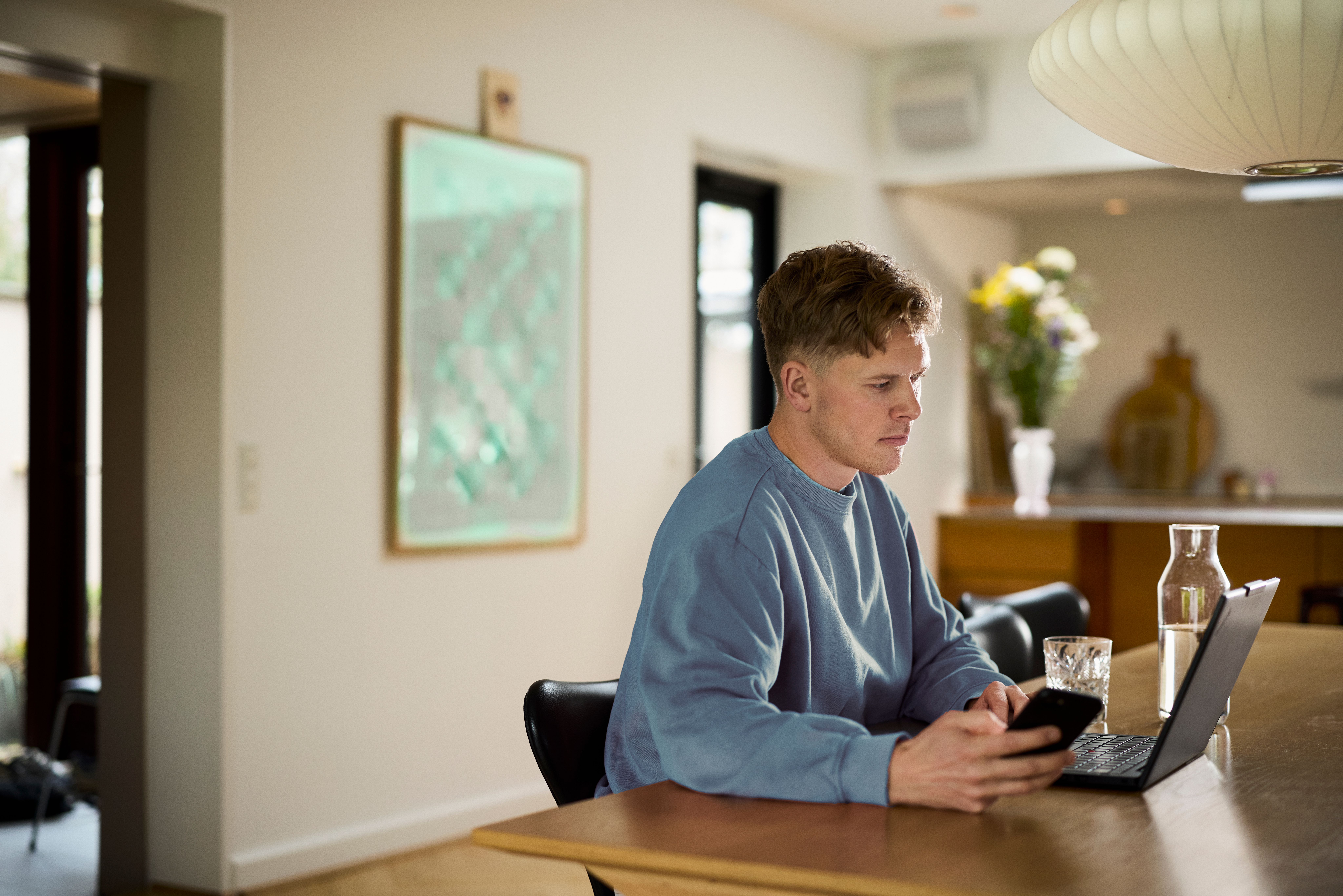 en mand sidder og tjekker reparationsforsikring ud fra FDM forsikringer